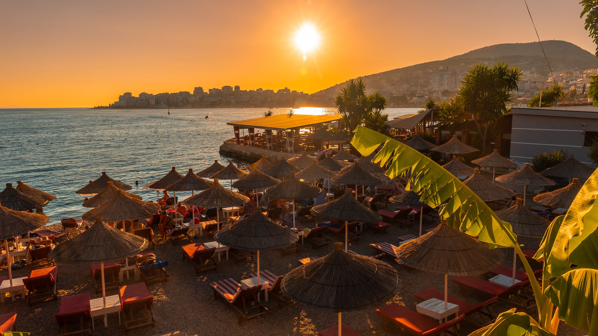 a beach with umbrellas and chairs and a beach in the background