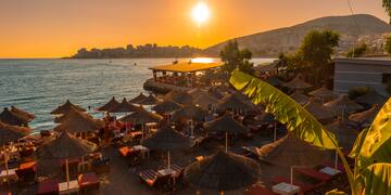 a beach with umbrellas and chairs and a beach in the background