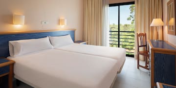 a room with two beds and a chair