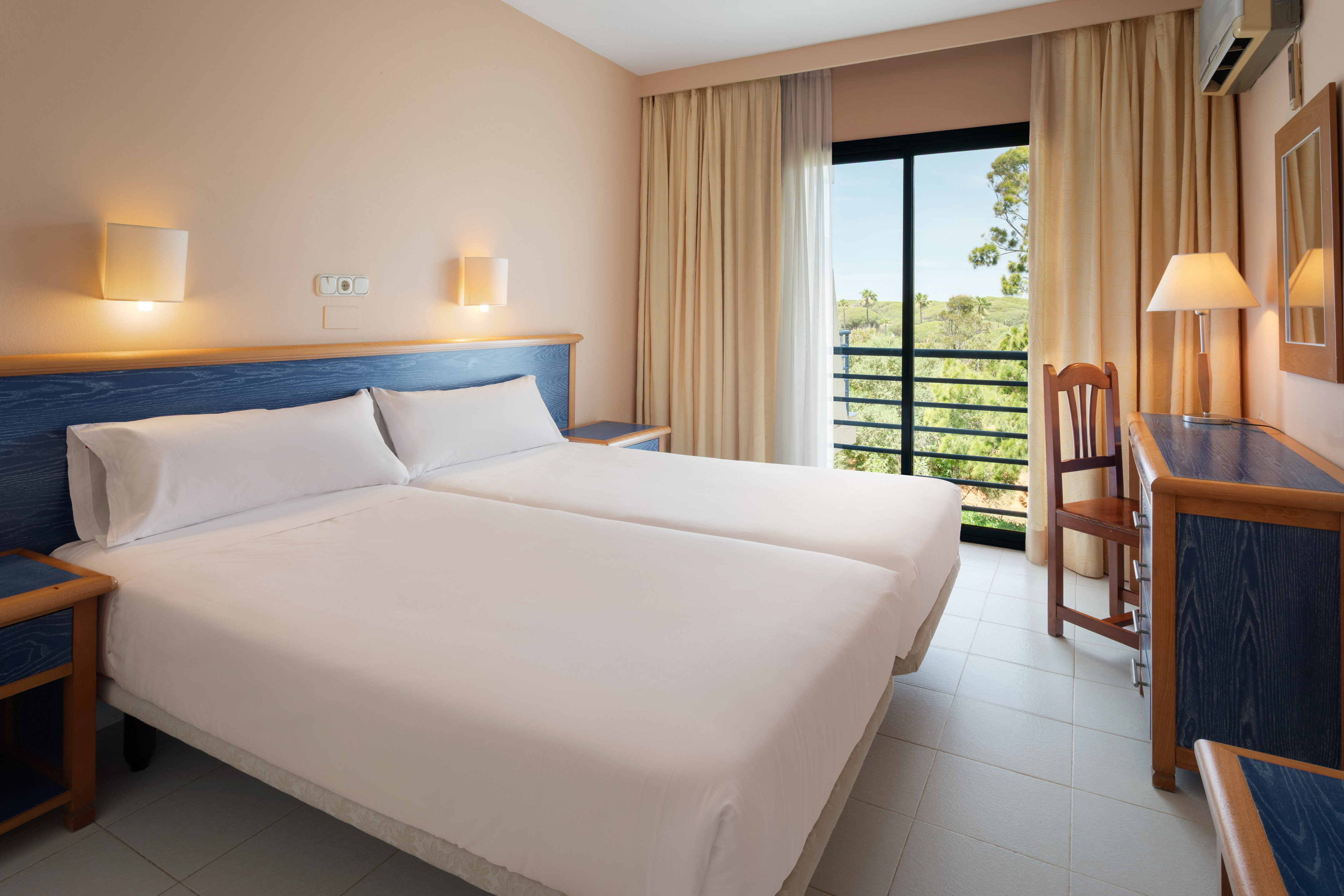 a room with two beds and a chair