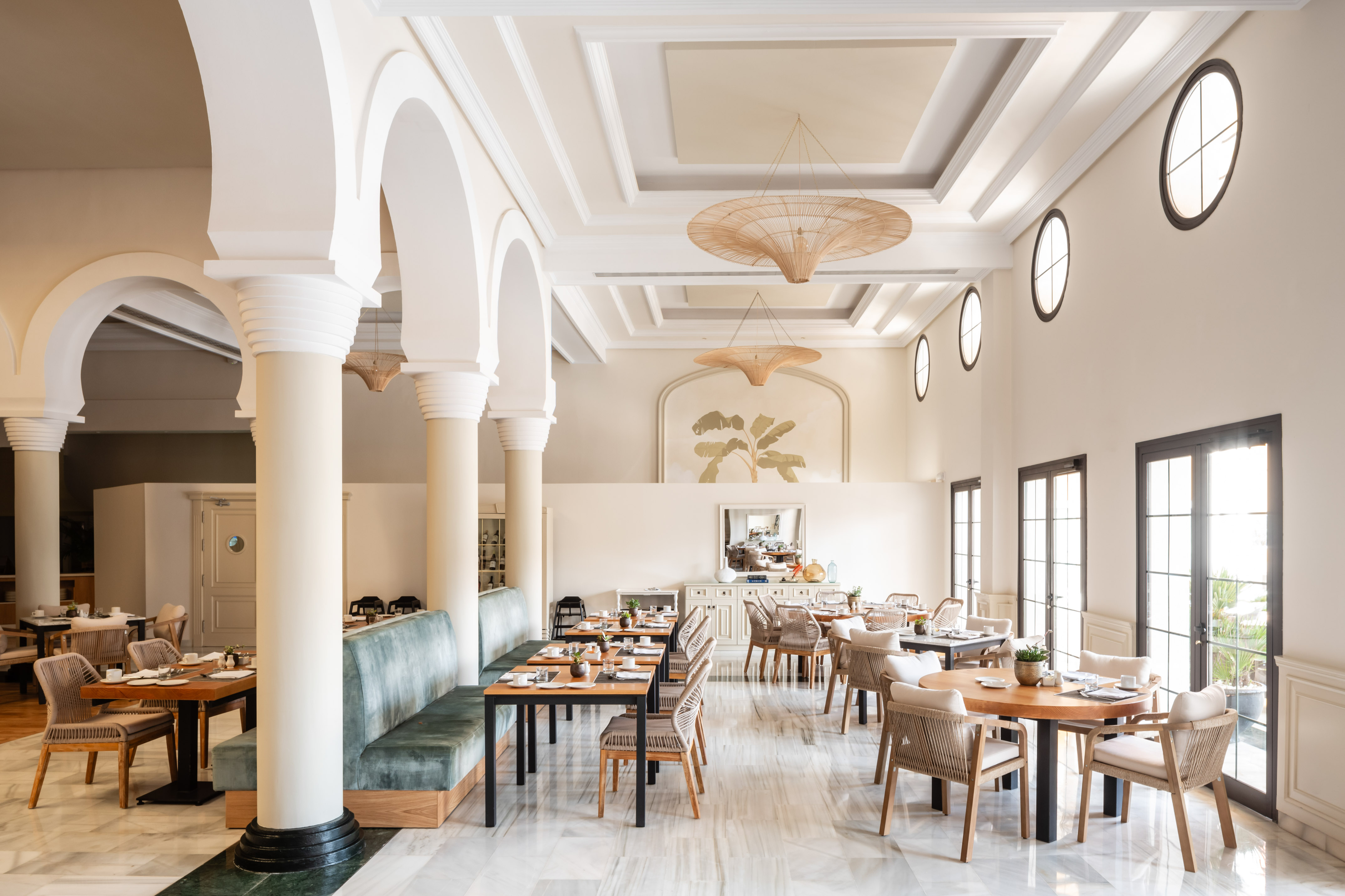 Elegant restaurant with architectural arches, modern decor, and natural light.