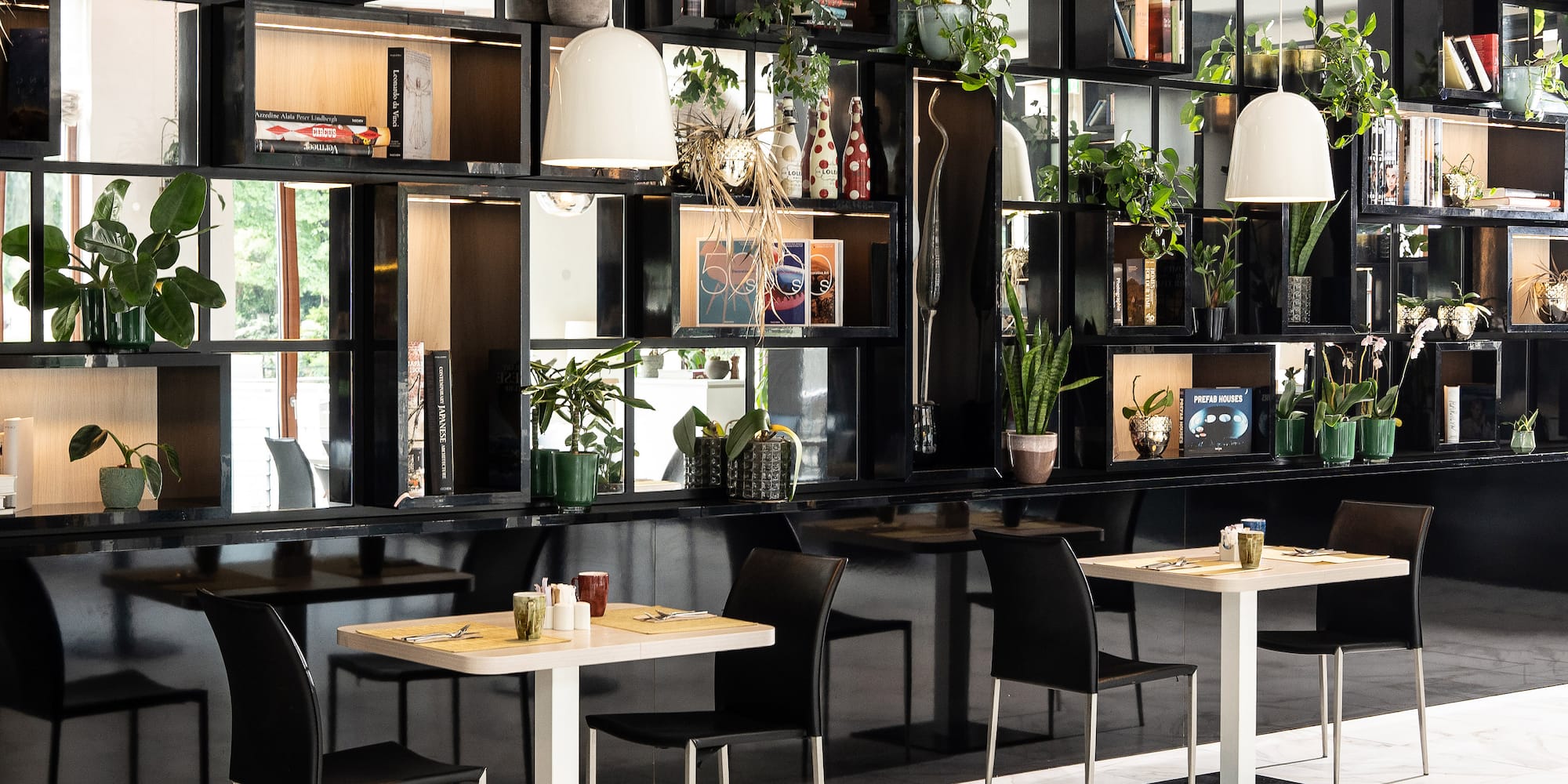a room with black shelves and tables and chairs