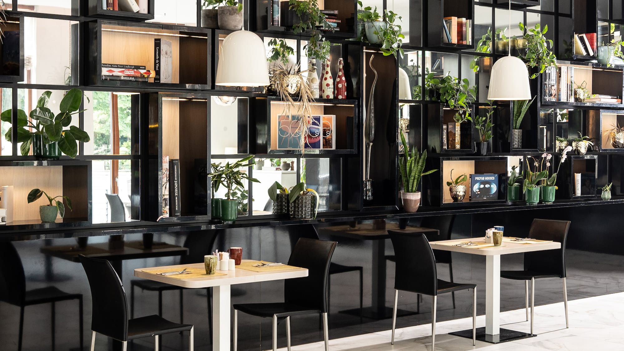 a room with black shelves and tables and chairs