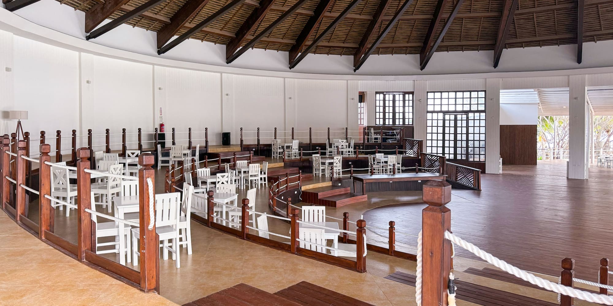 a room with white chairs and a wooden ceiling