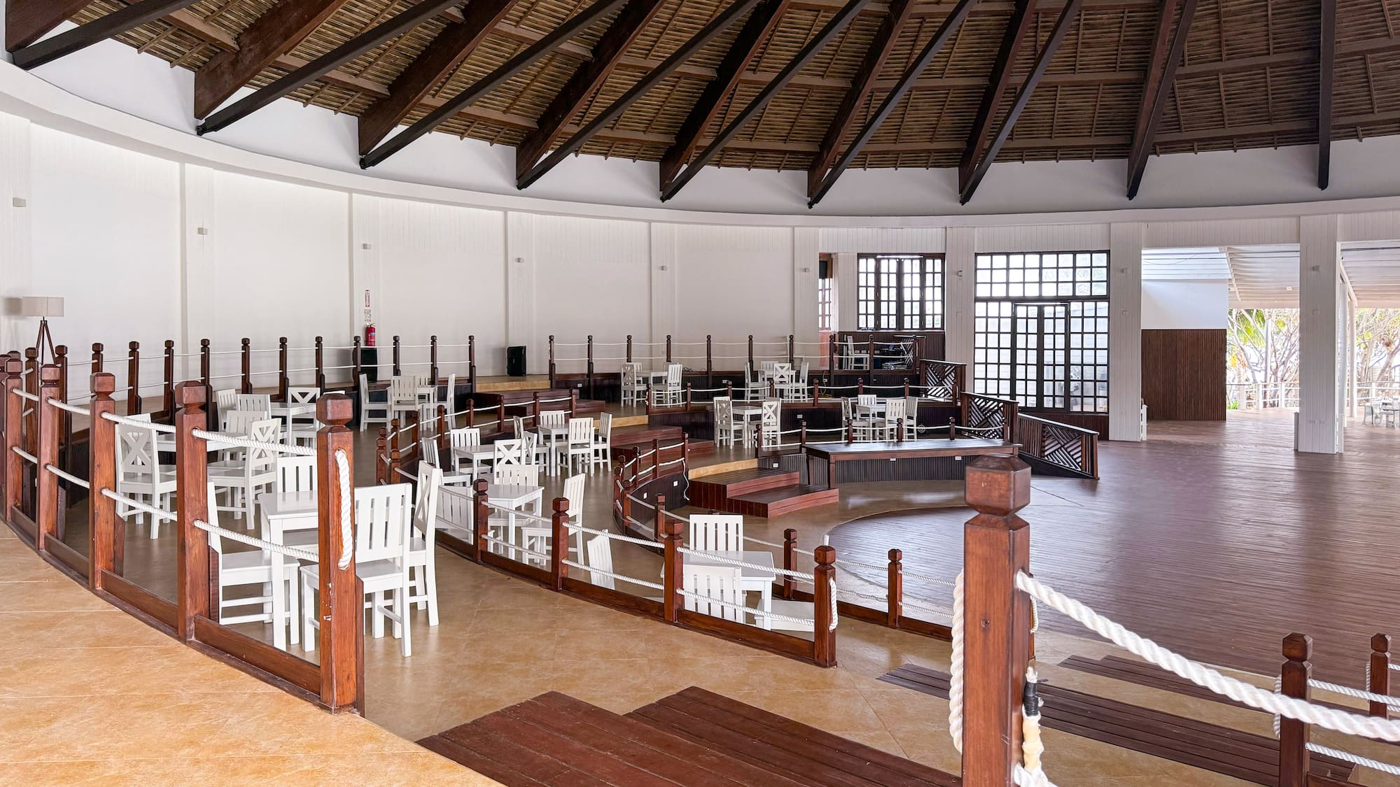a room with white chairs and a wooden ceiling