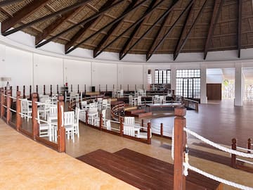 a room with white chairs and a wooden ceiling
