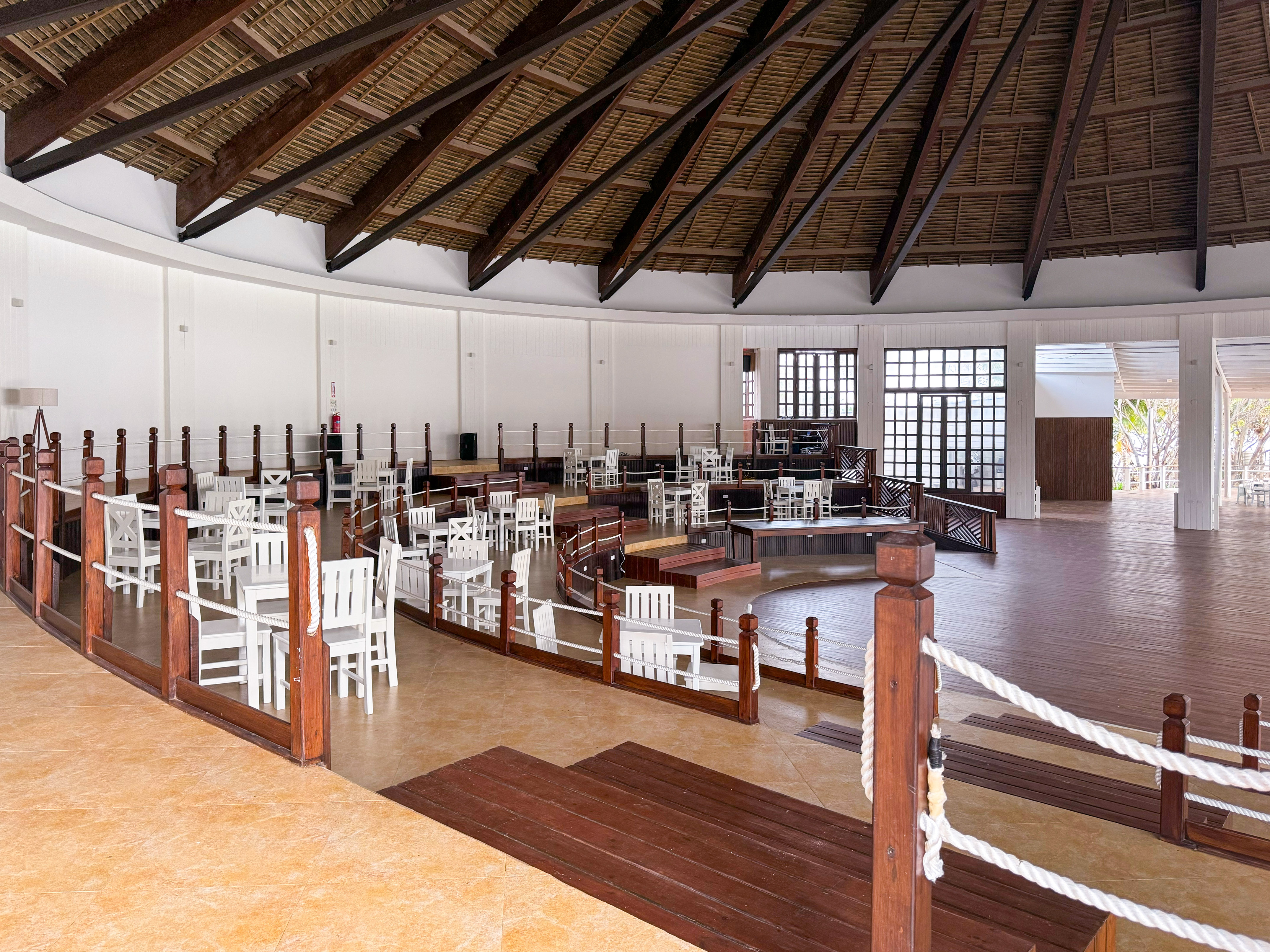 a room with white chairs and a wooden ceiling