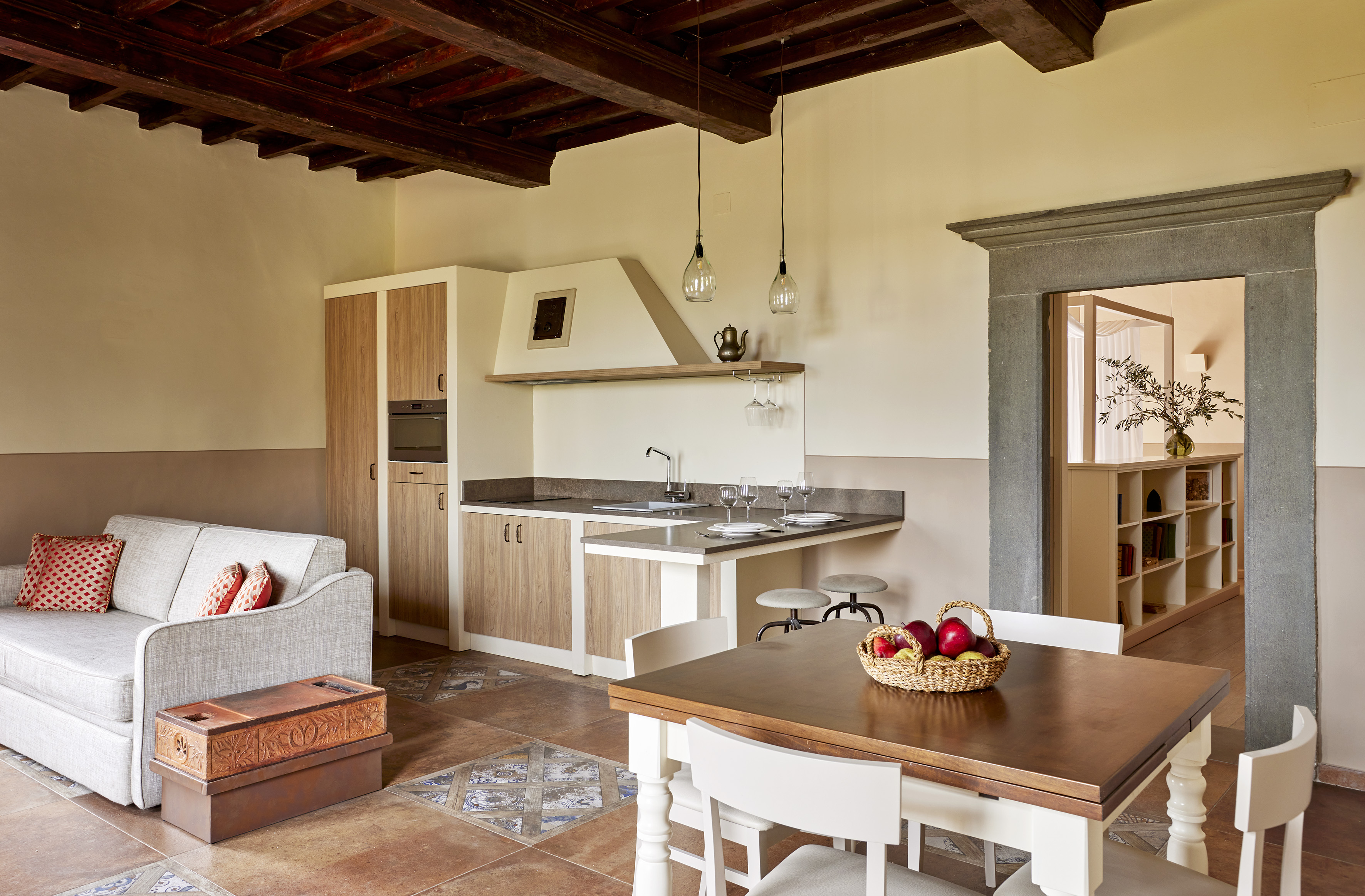 Tuscan-style studio apartment with kitchenette, dining area, and beamed ceiling.