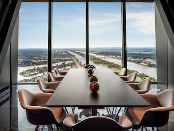 a room with a table and chairs and a view of a river and city