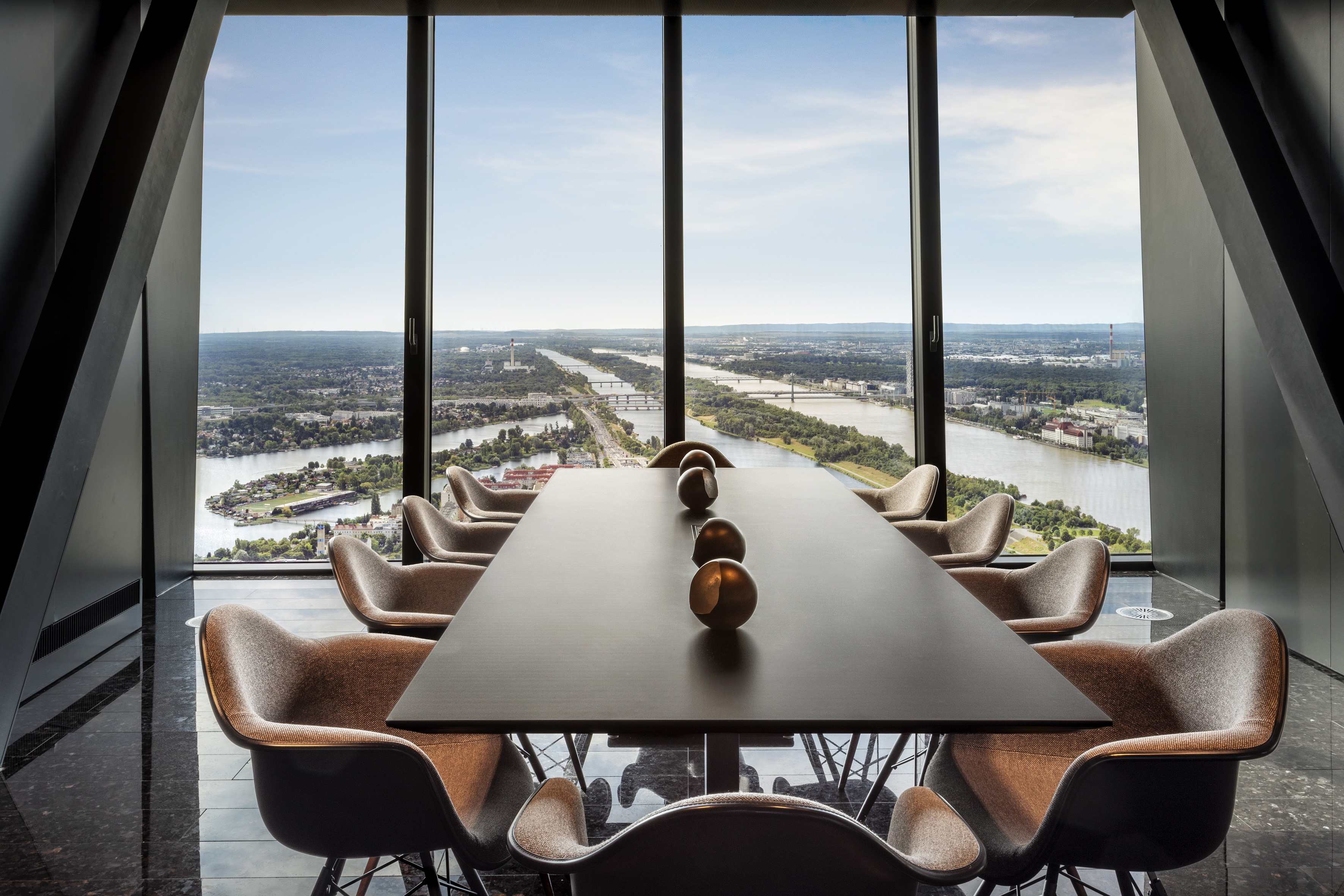 a room with a table and chairs and a view of a river and city