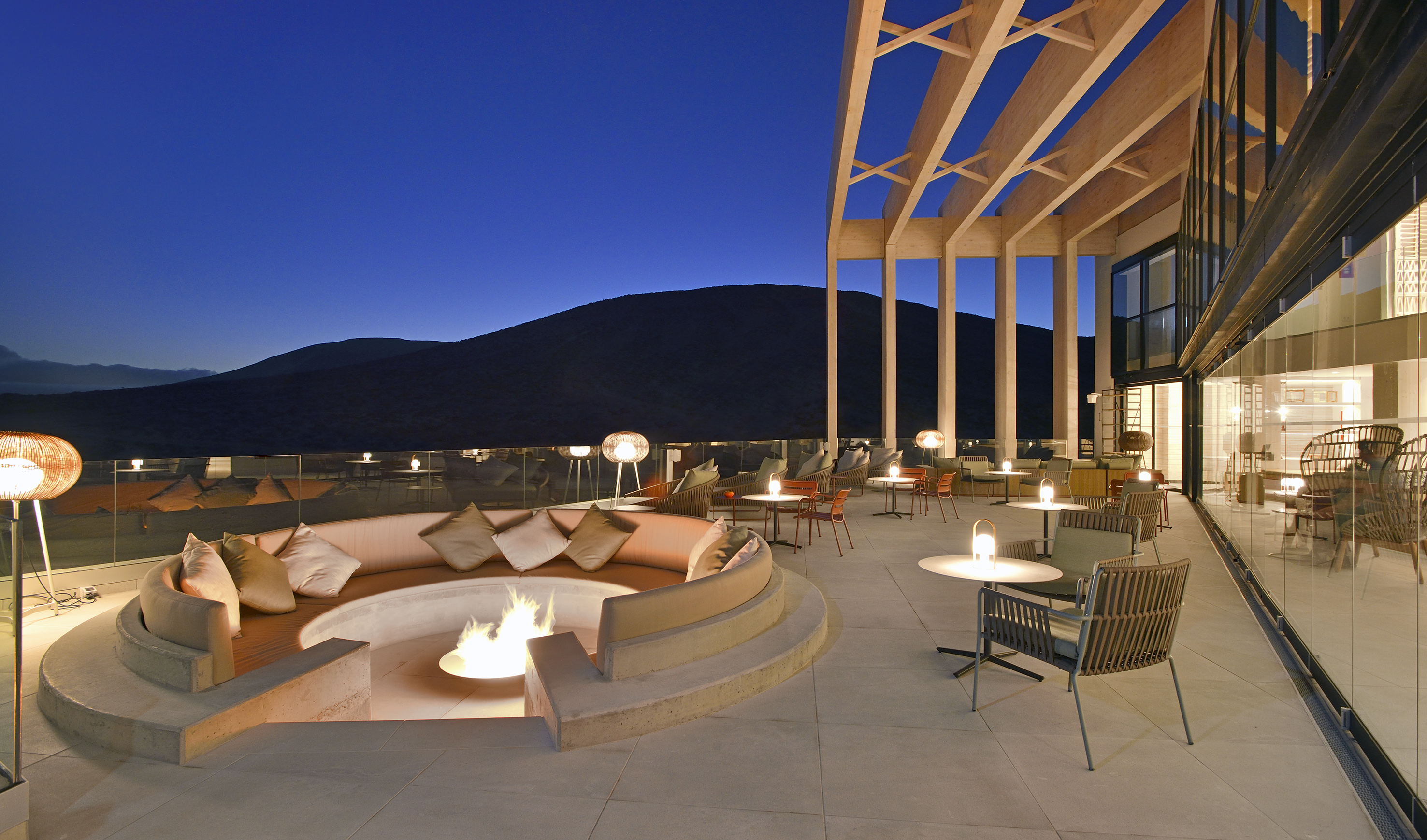 a patio with a fire pit and chairs