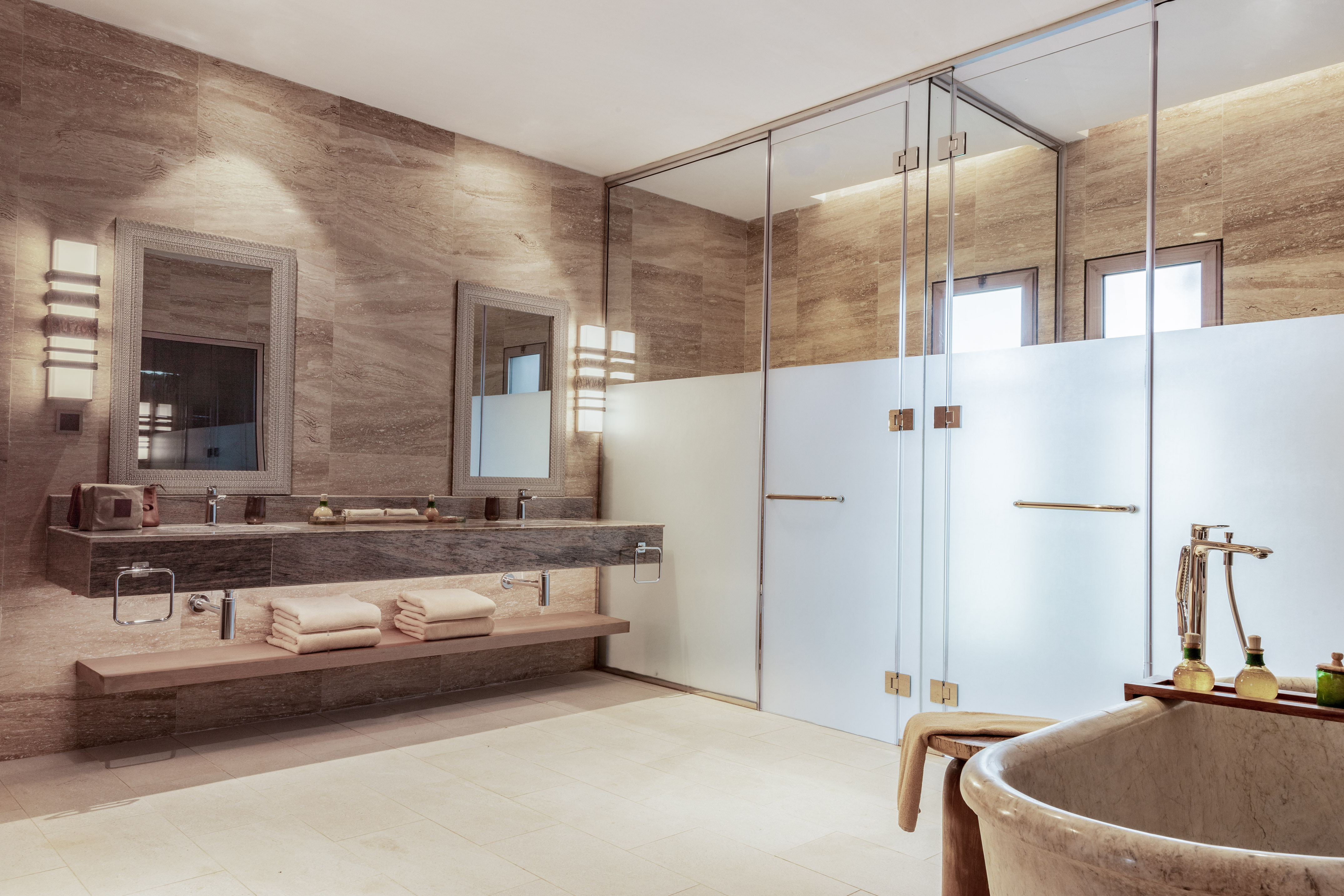 Luxurious marble bathroom with double vanity, glass shower, and freestanding tub.