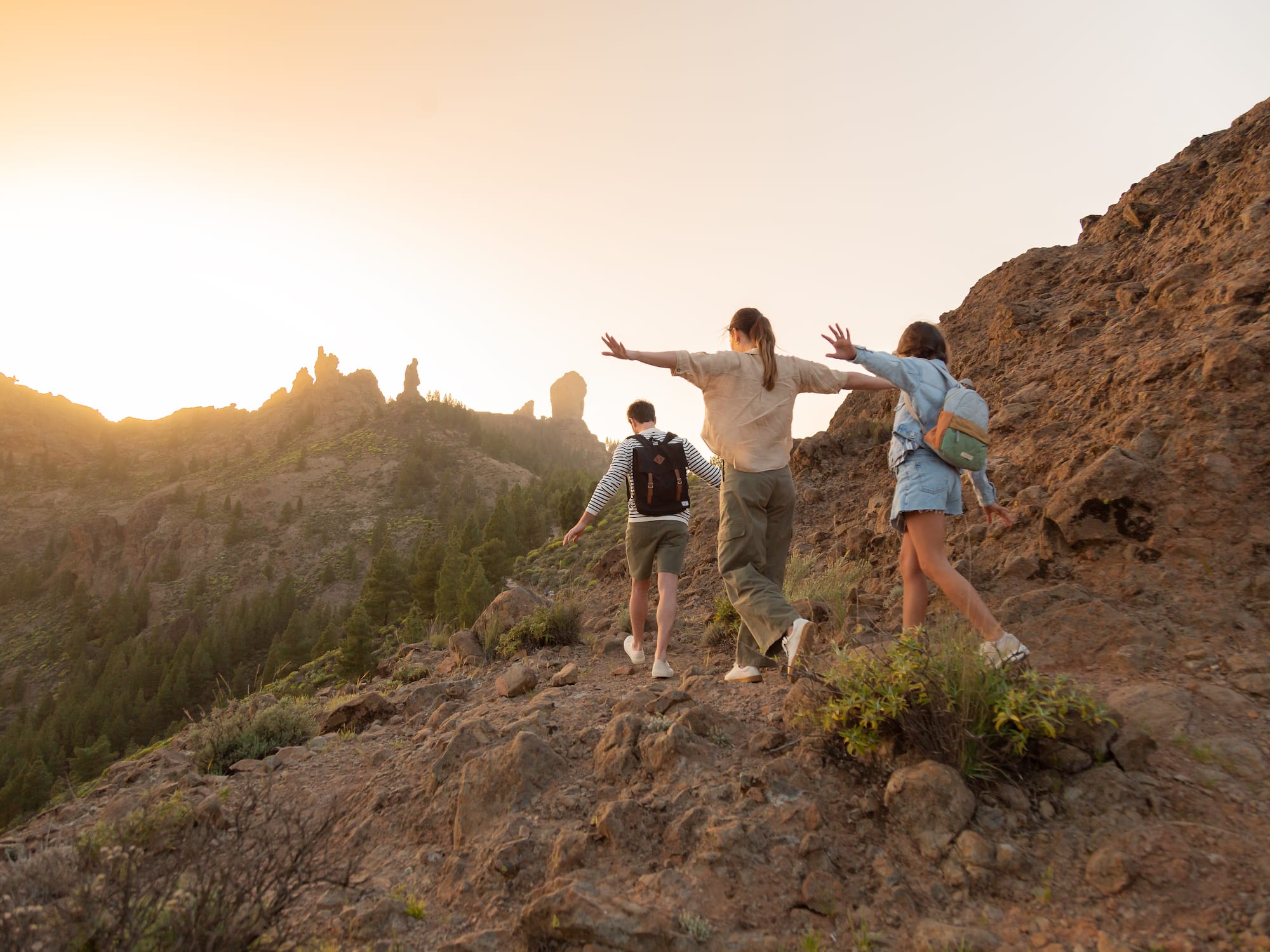 a group of people walking on a rocky hill