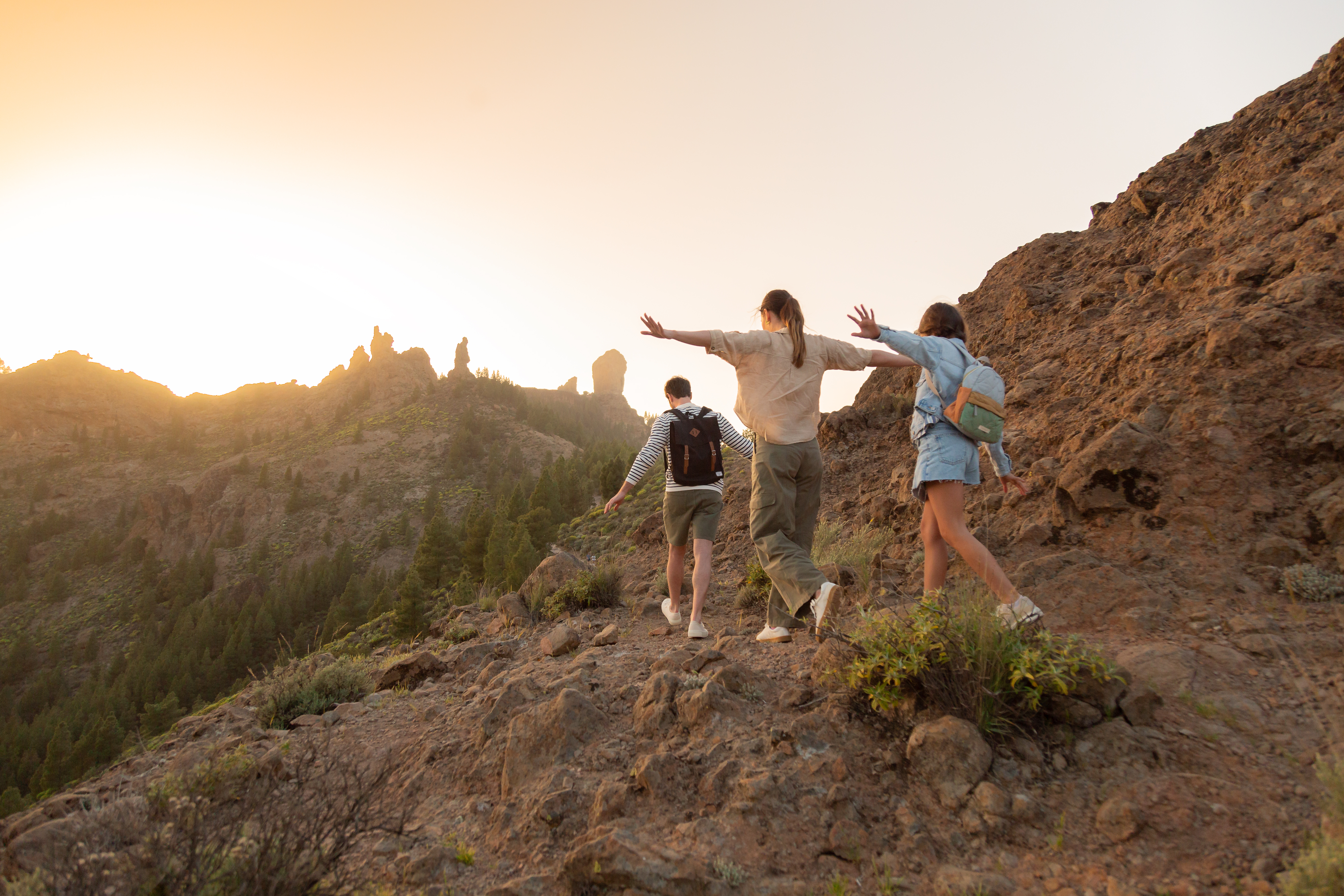 a group of people walking on a rocky hill