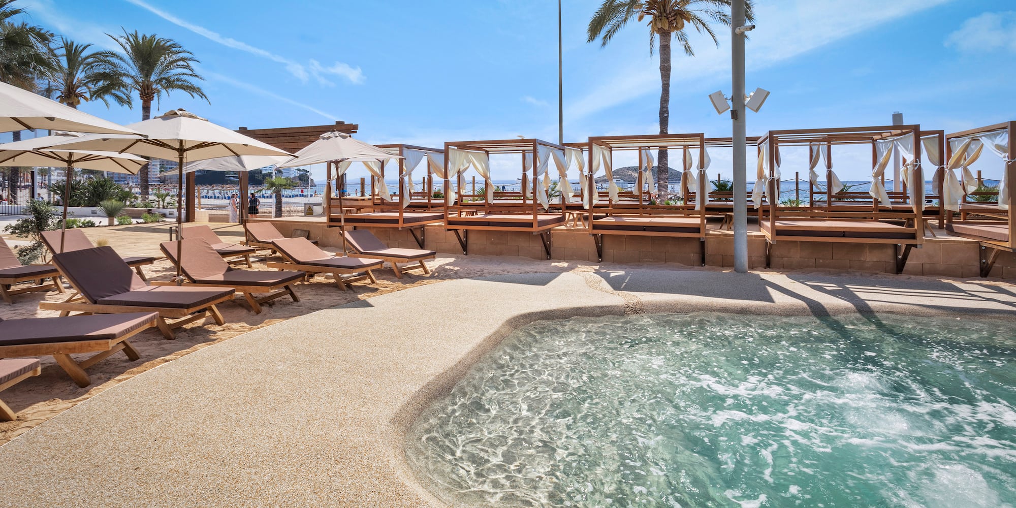 a pool with lounge chairs and umbrellas