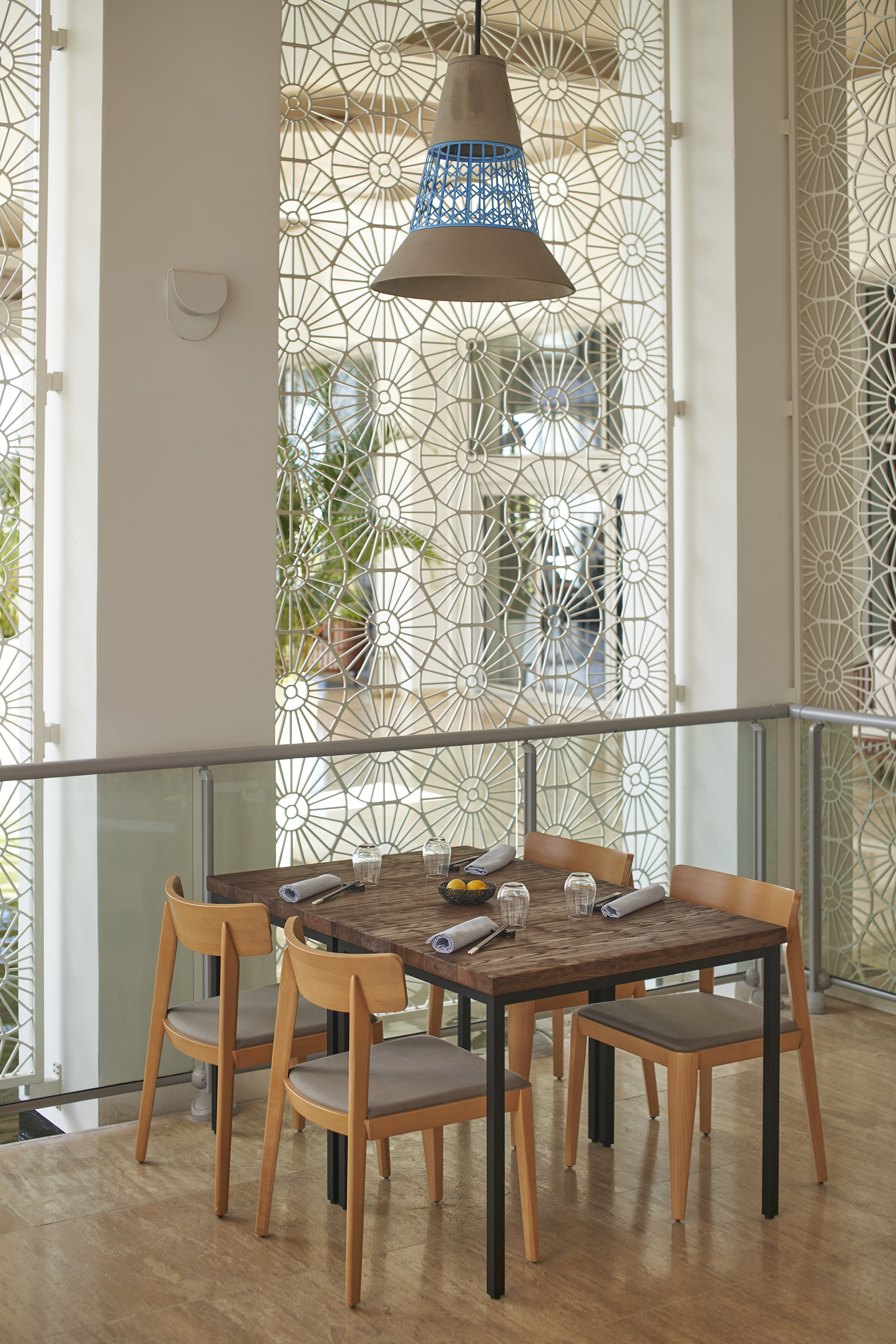 Restaurant dining table, modern chairs, stylish pendant light, geometric screens.
