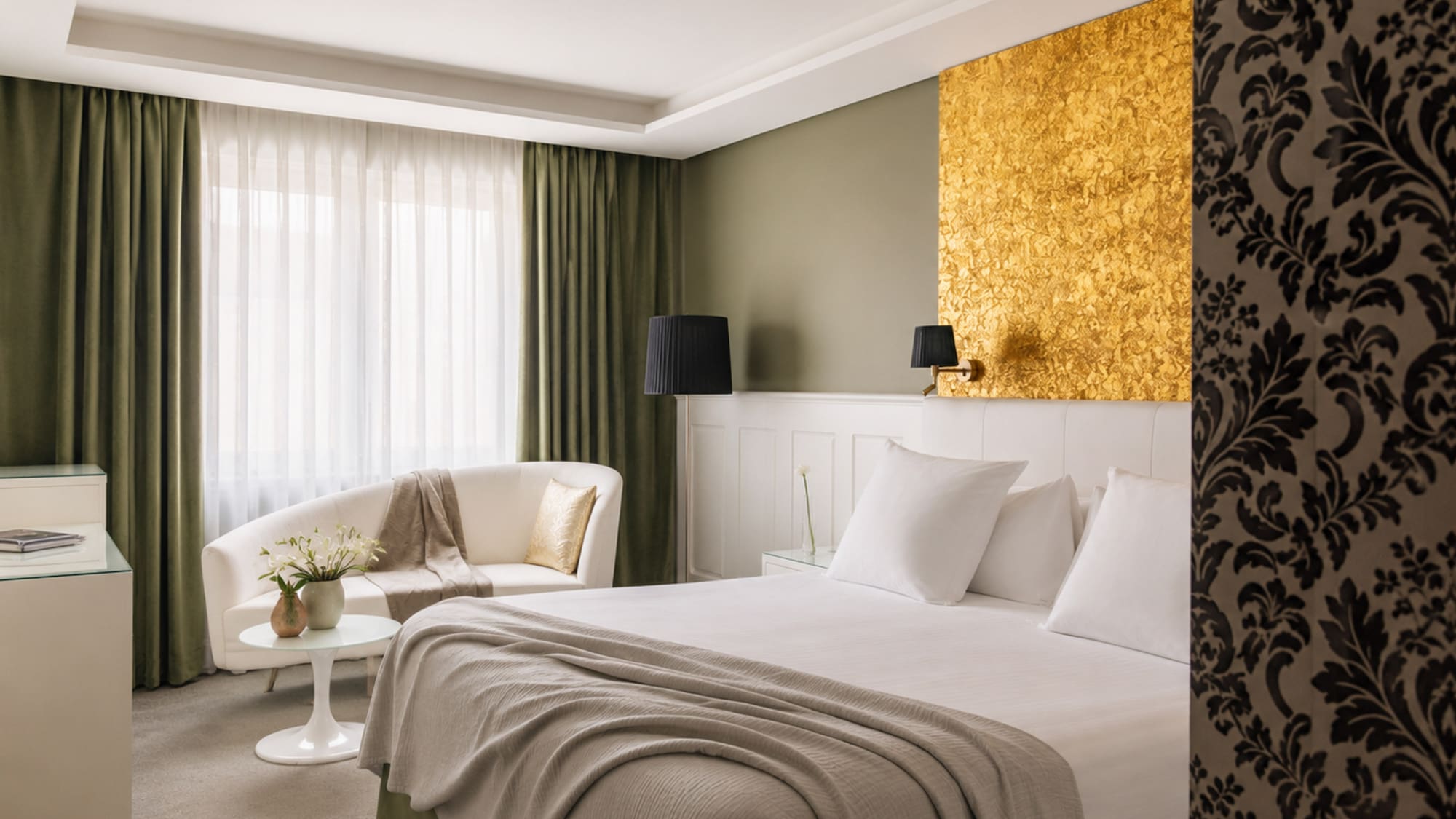 Luxury hotel room with gold accent wall, white bed, olive green curtains.