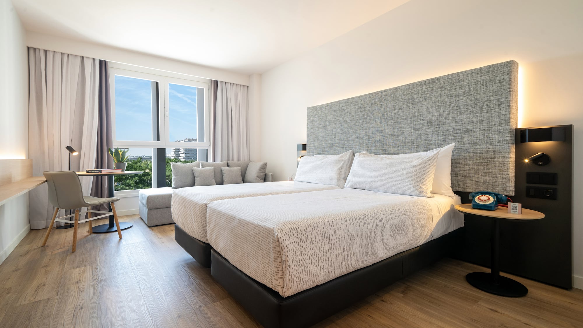 a room with two beds and a table and chairs