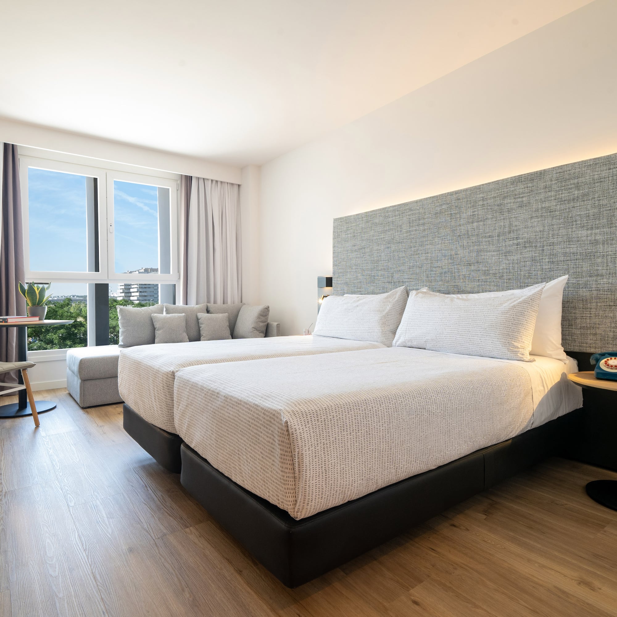 a room with two beds and a table and chairs