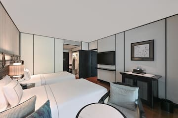 a room with two beds and a television