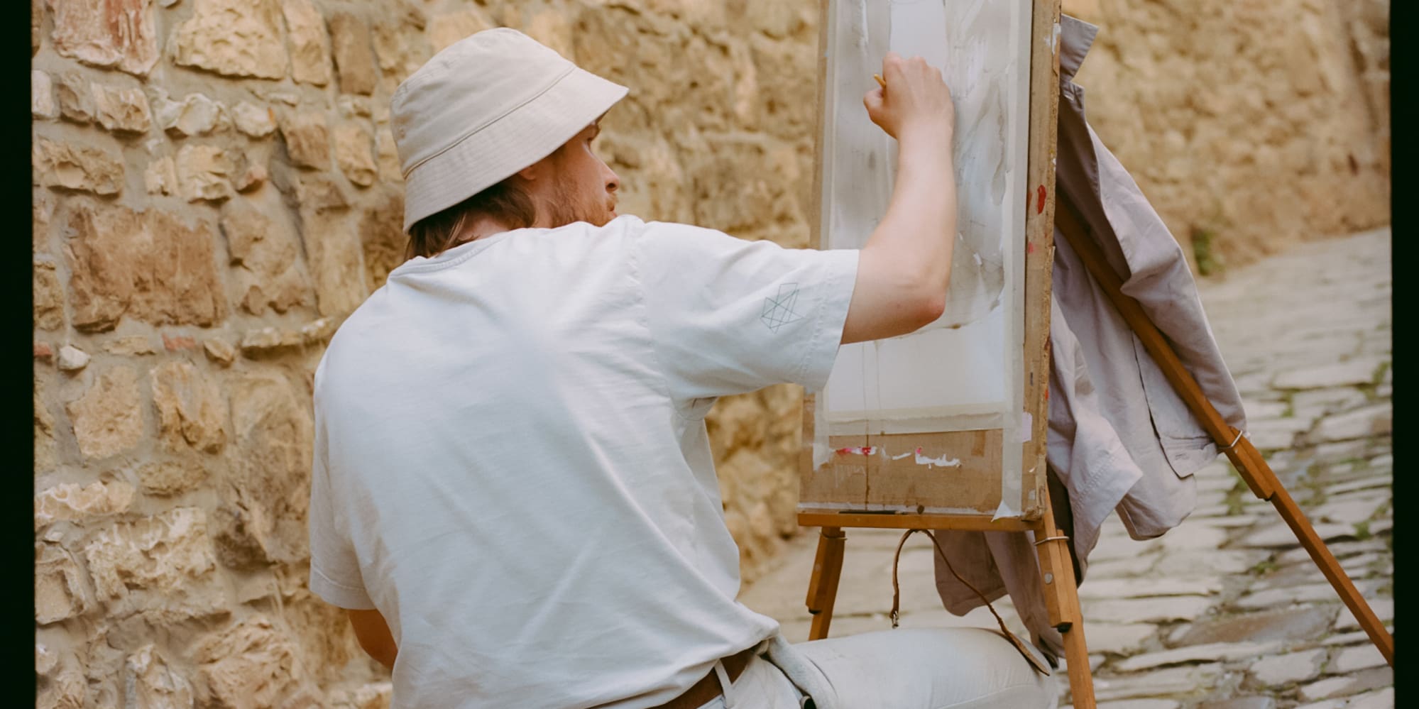 a man painting on a canvas