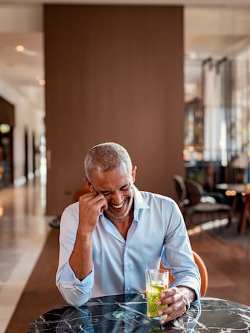 a man smiling at a drink