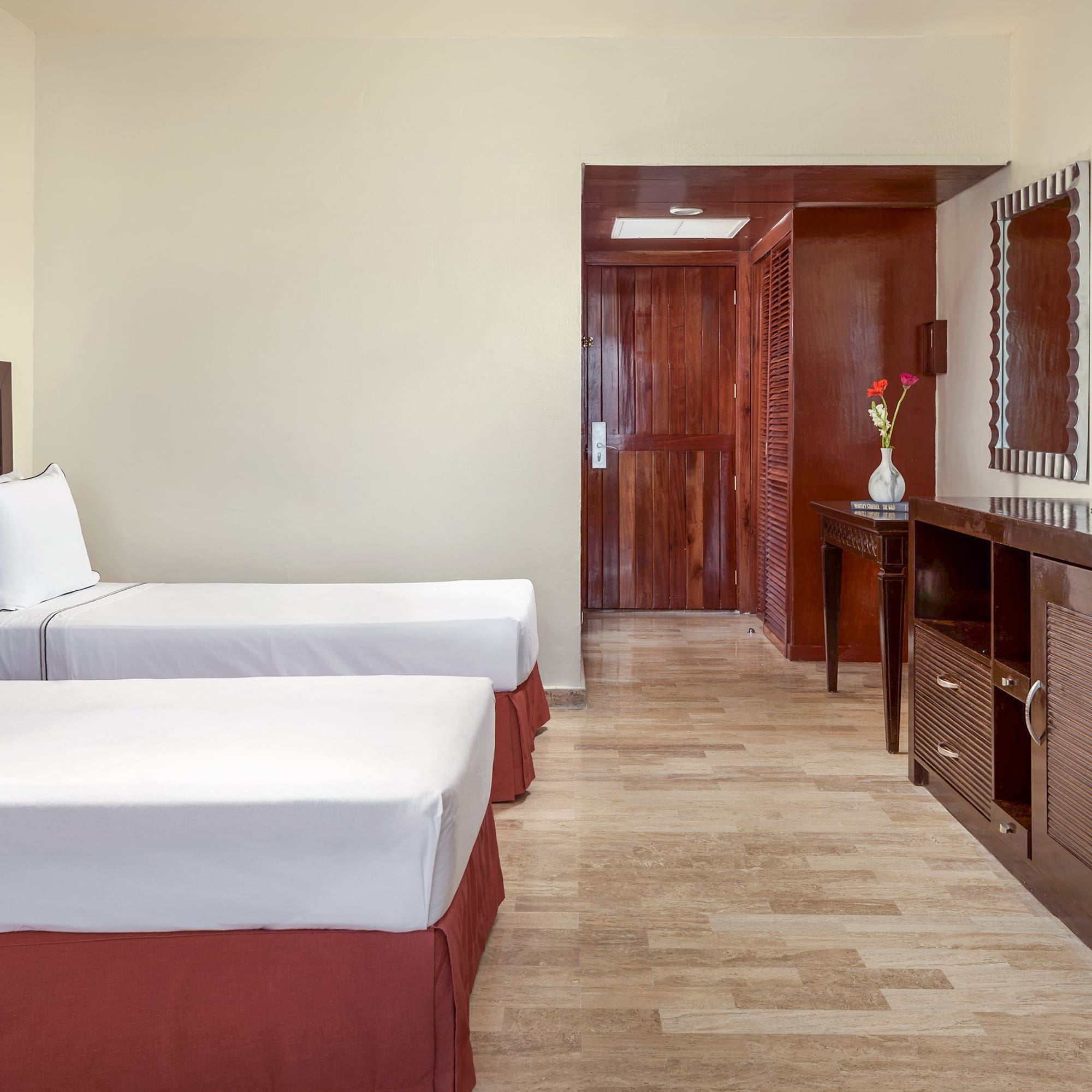 a room with two beds and a mirror