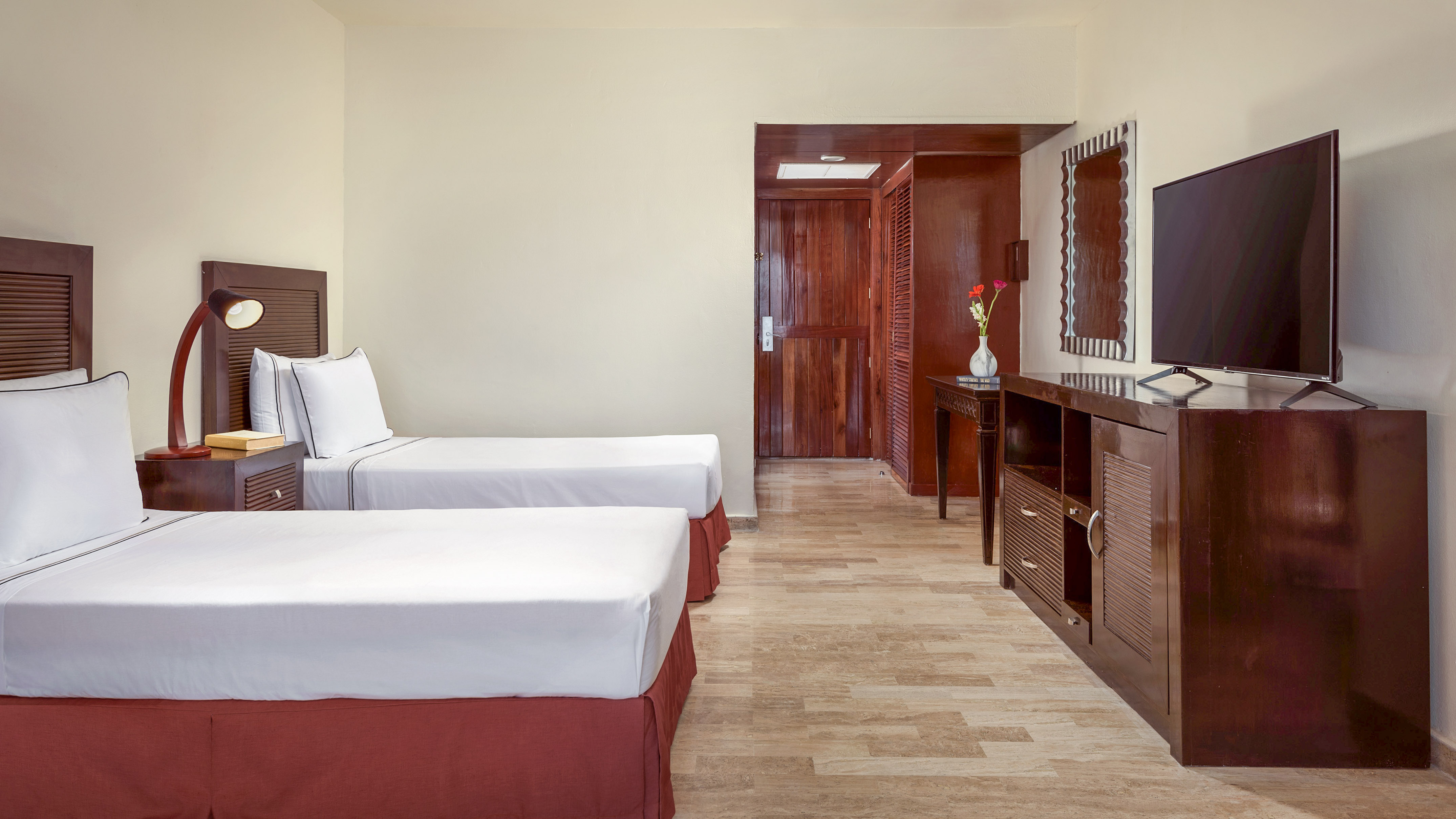 a room with two beds and a mirror