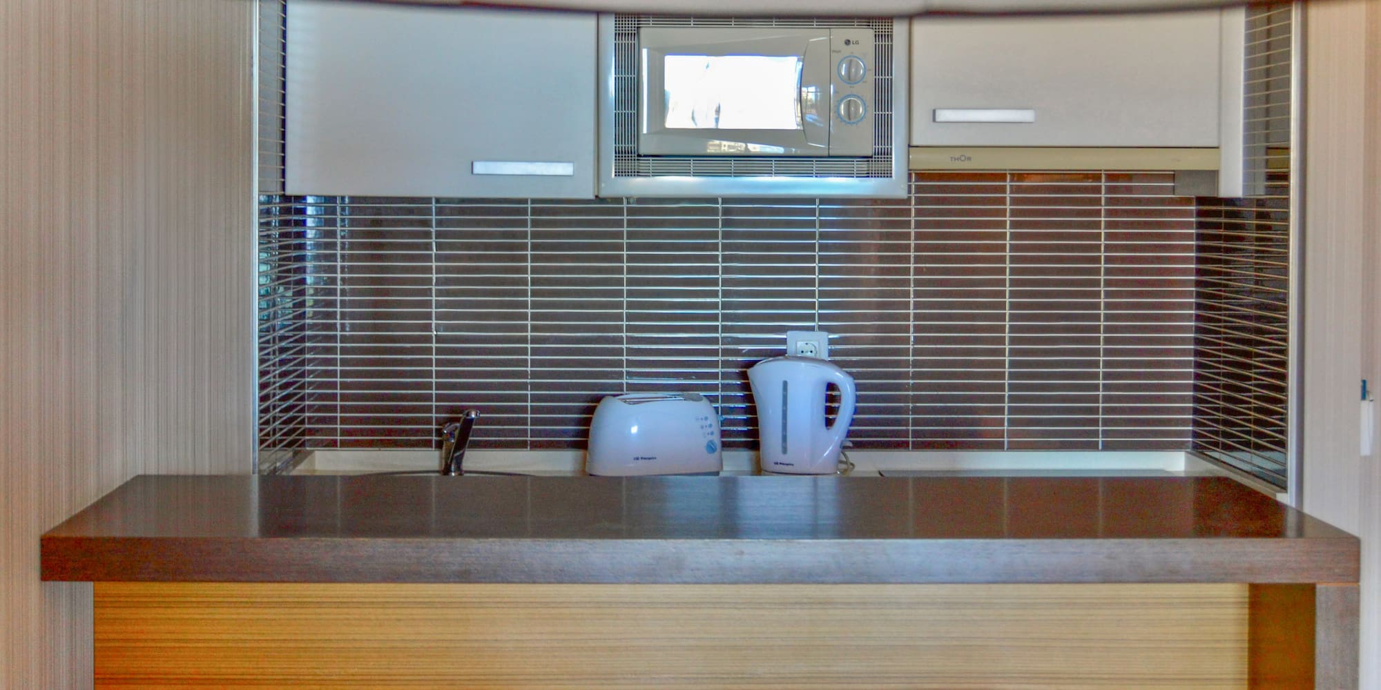 a kitchen with a microwave and a kettle