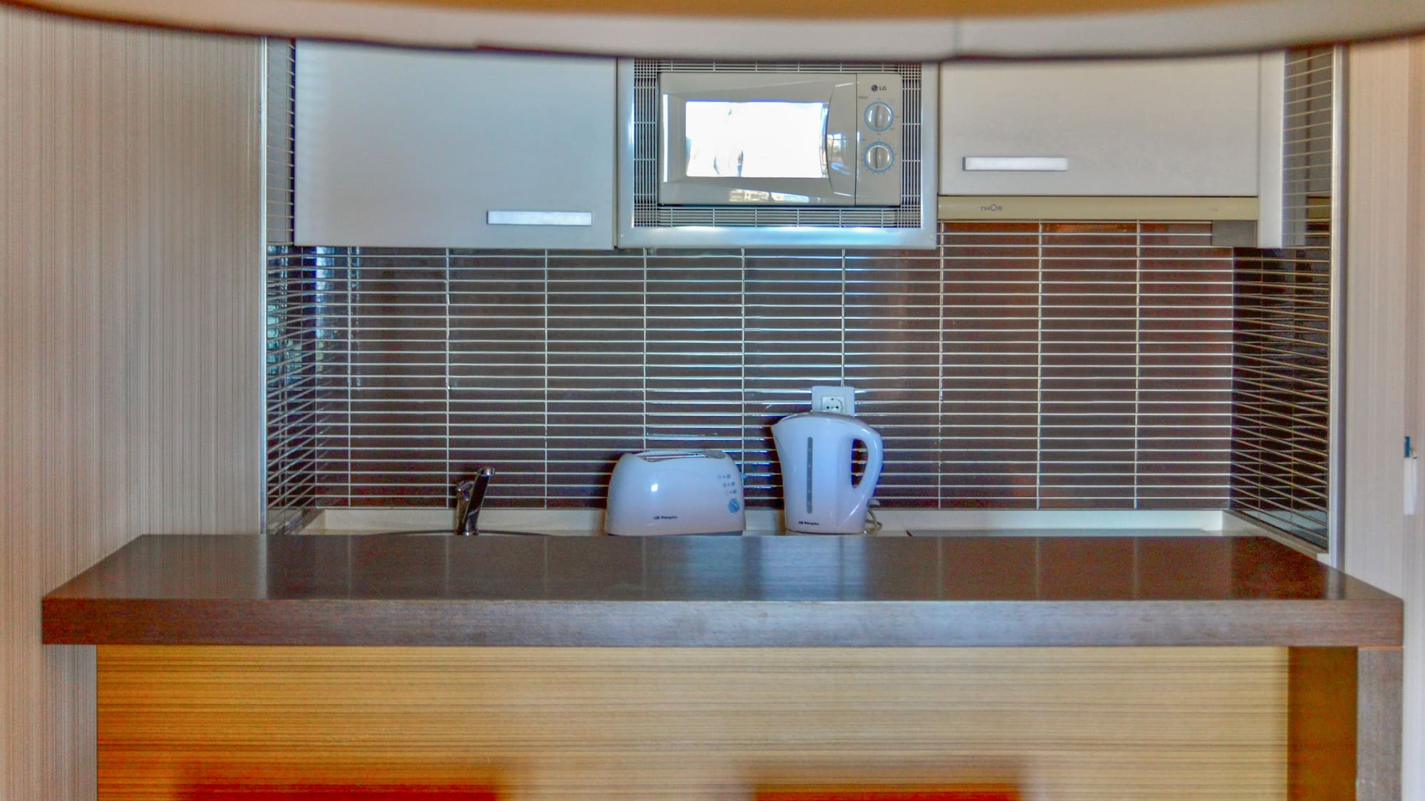 a kitchen with a microwave and a kettle