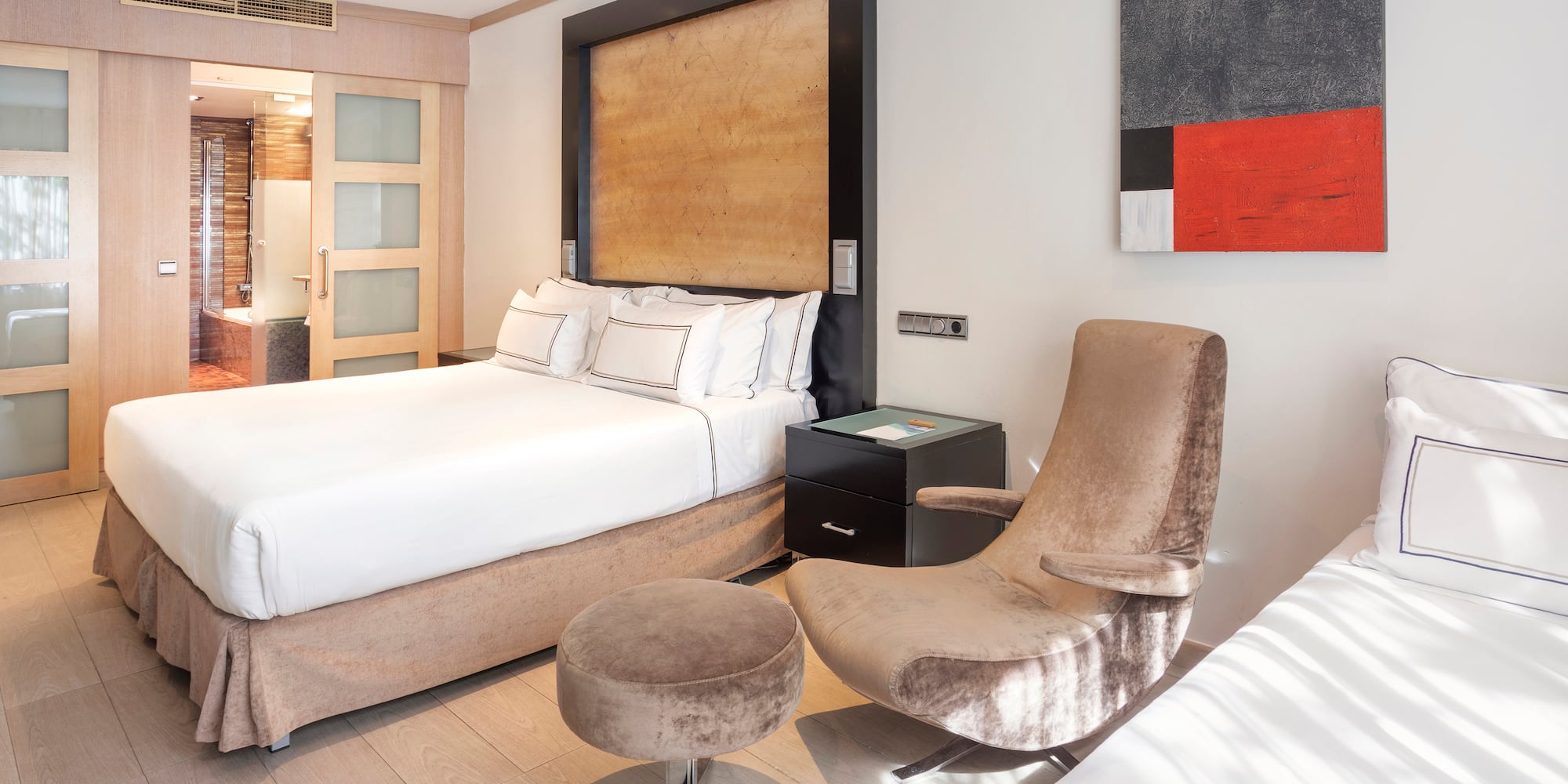 a bedroom with a bed and two chairs