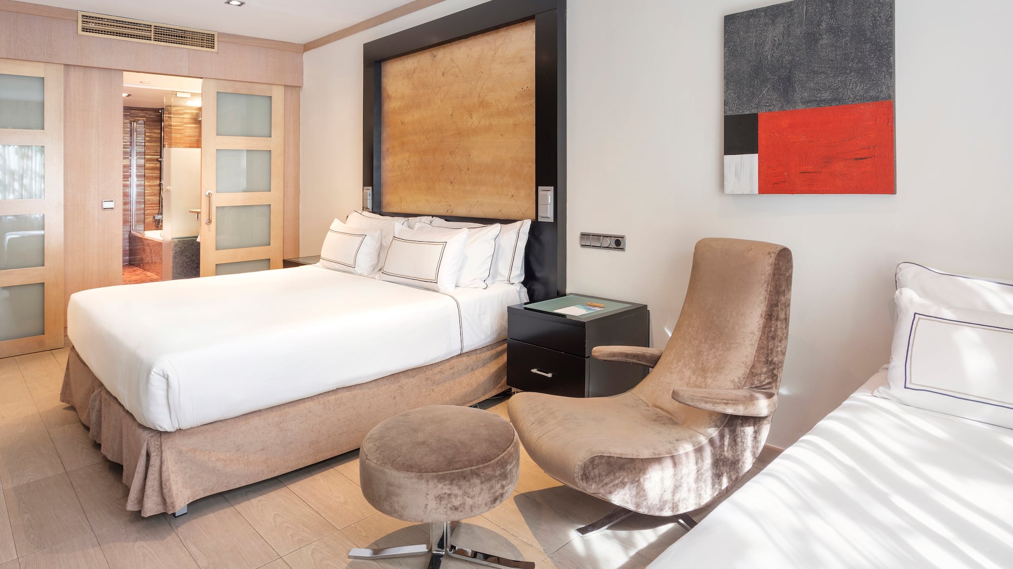 a bedroom with a bed and two chairs