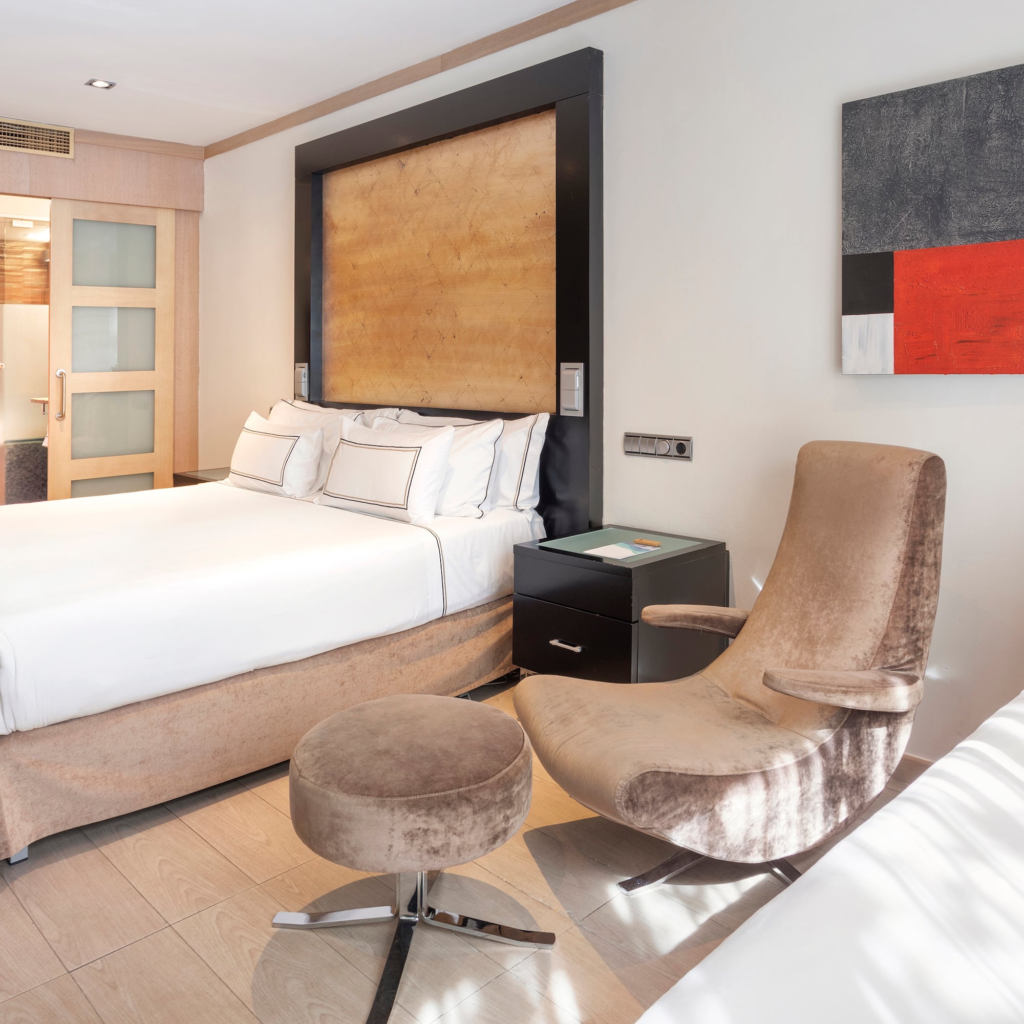 a bedroom with a bed and two chairs