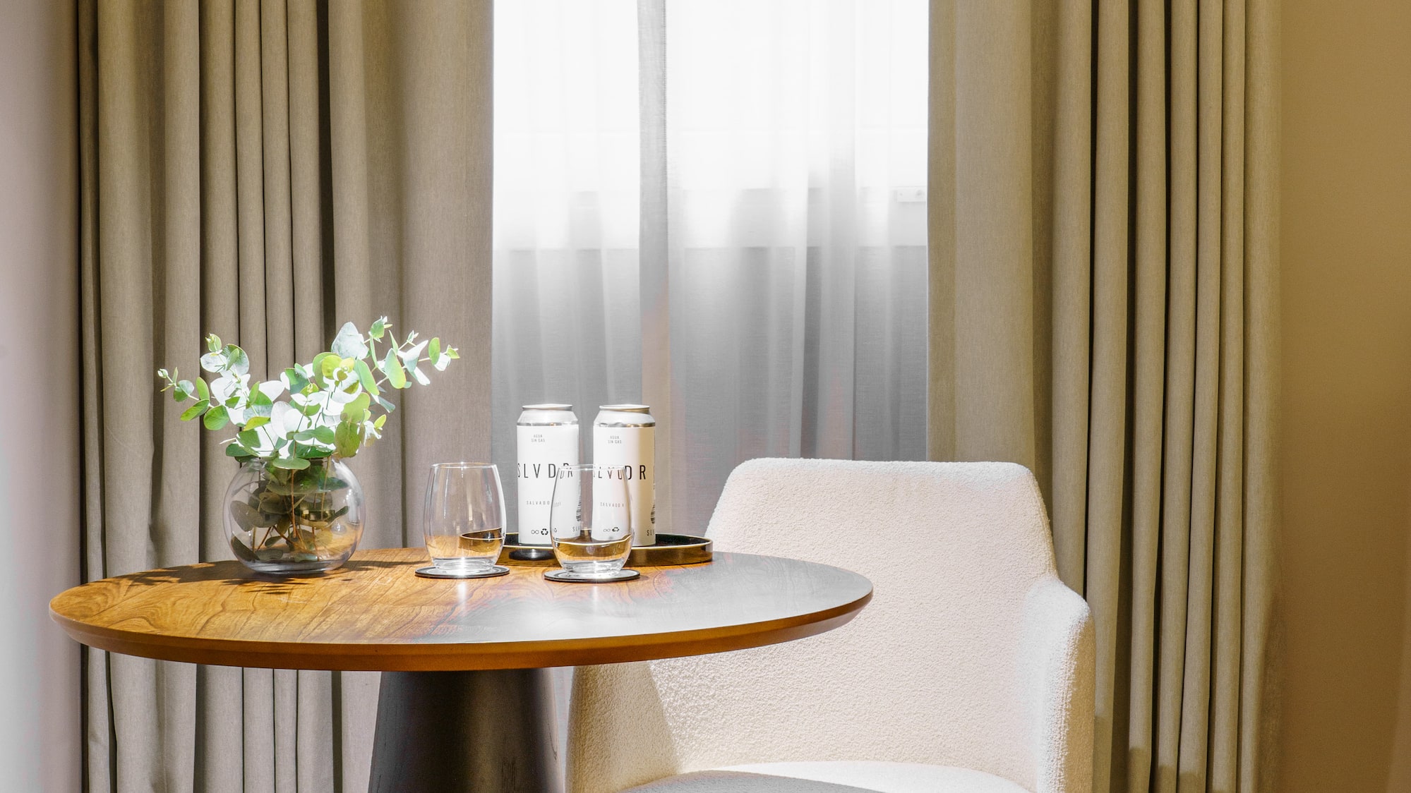 a table with a chair and a vase of flowers