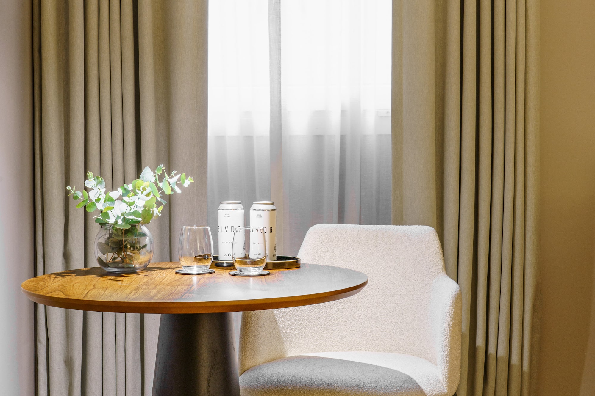 a table with a chair and a vase of flowers