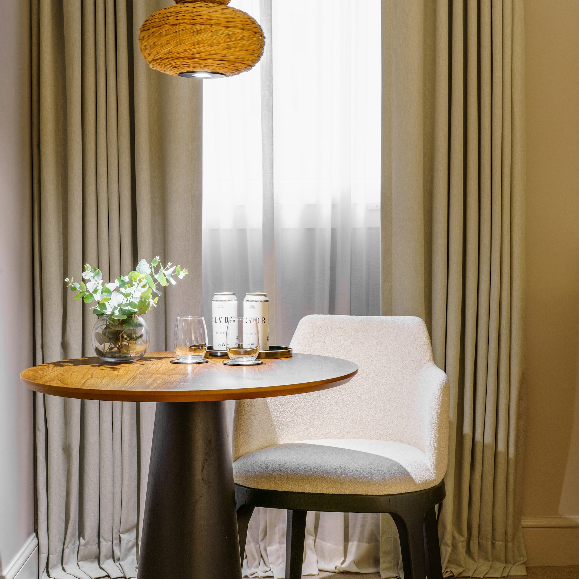 a table with a chair and a vase of flowers