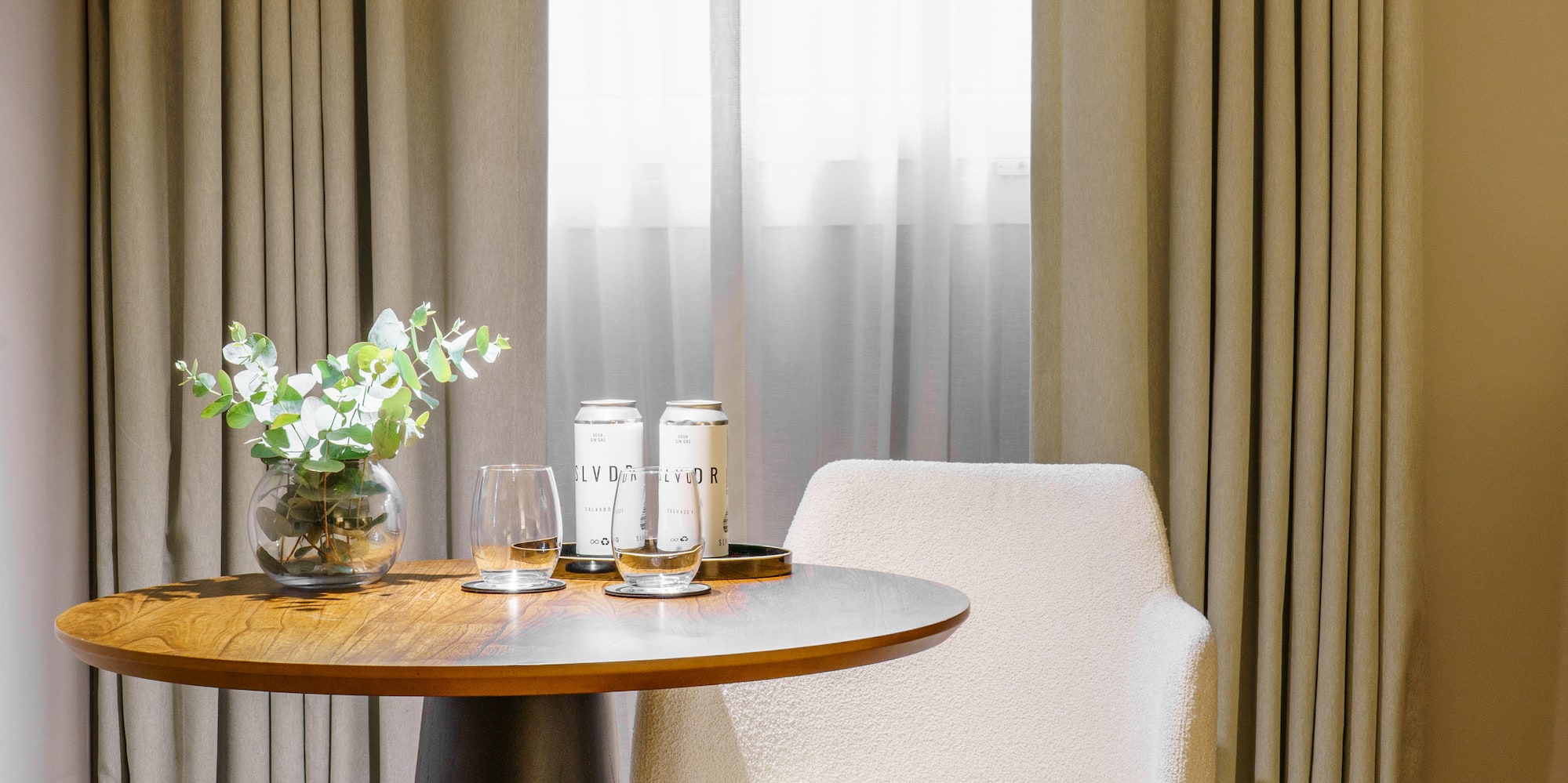 a table with a chair and a vase of flowers