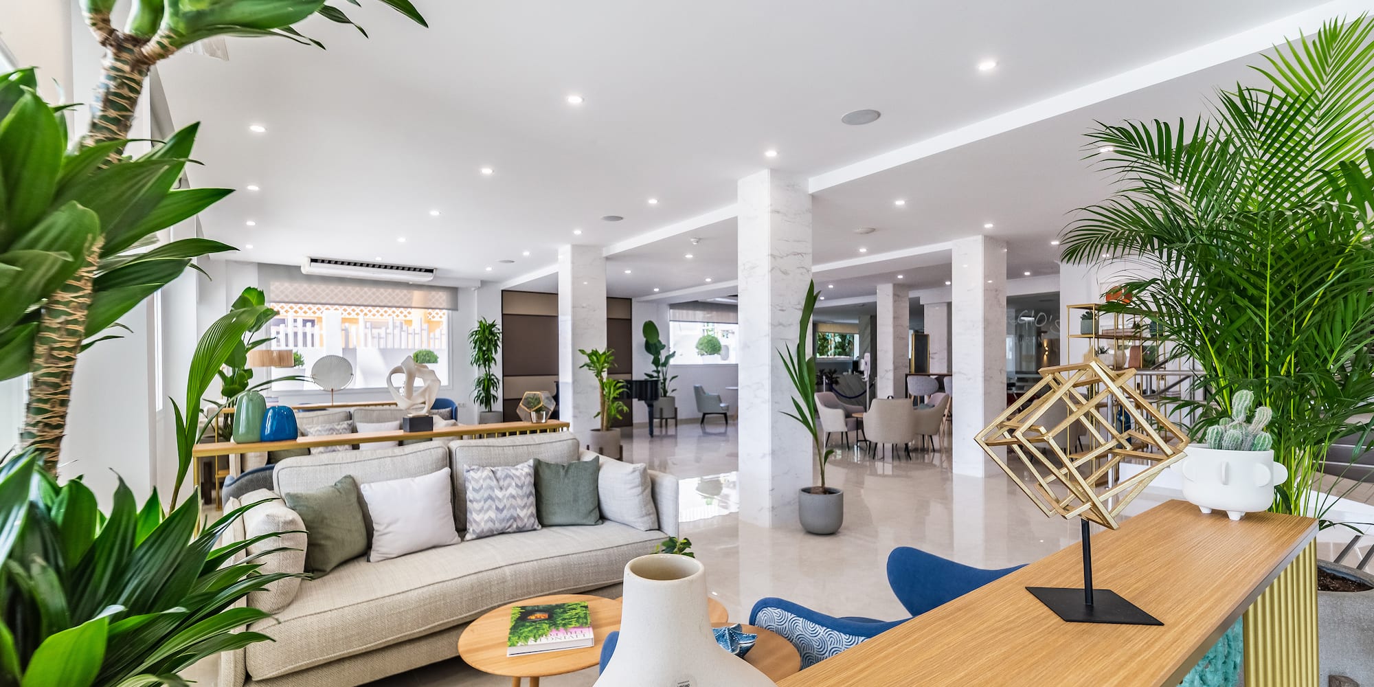 a room with a couch and tables and plants