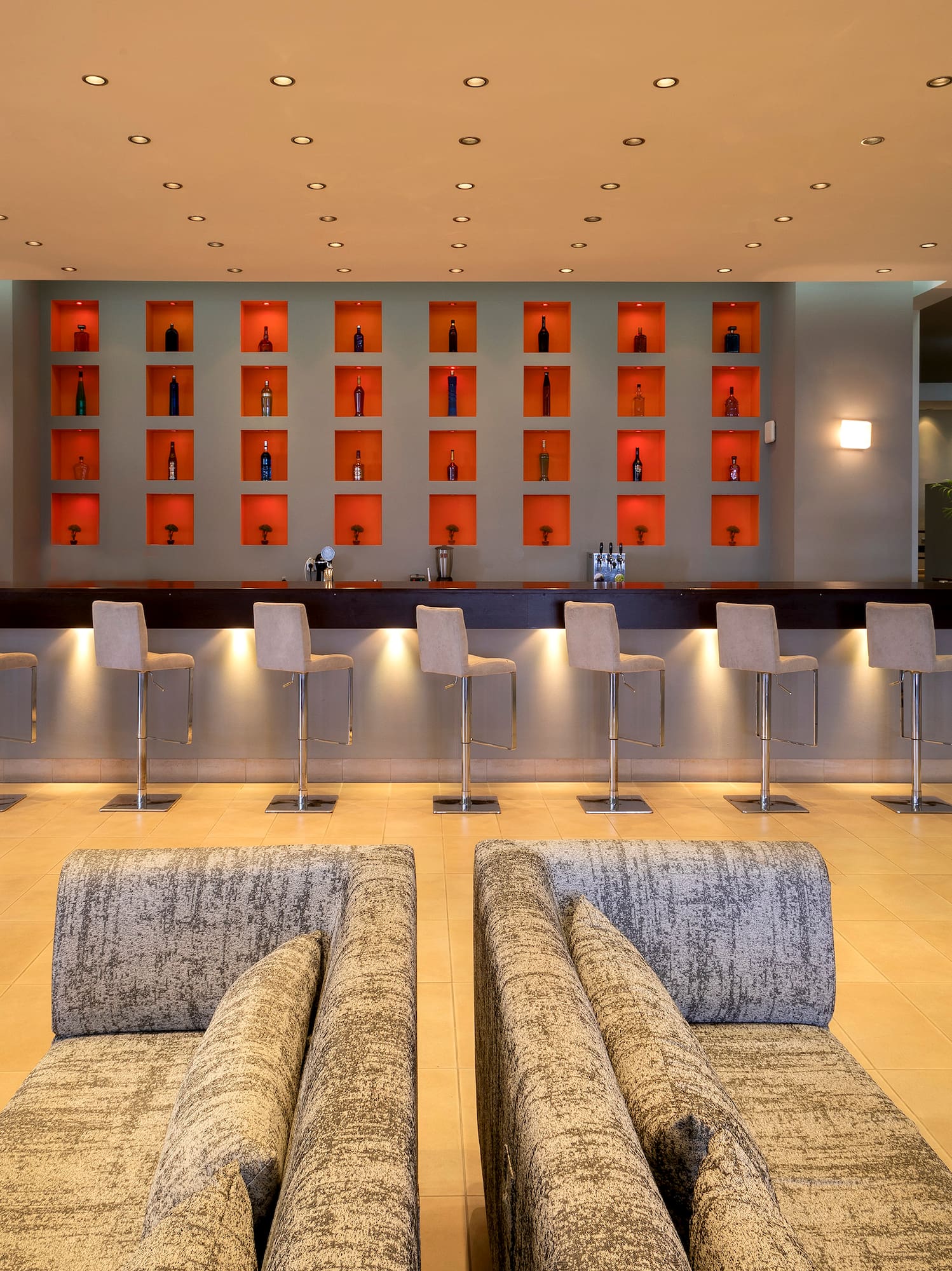 a room with a bar and chairs