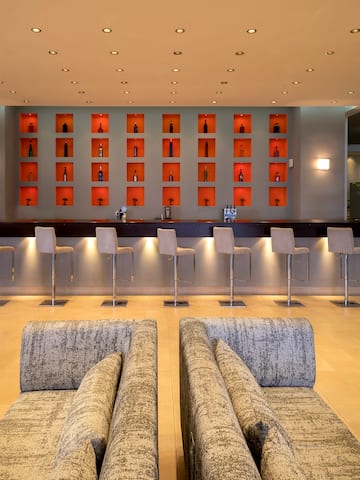 a room with a bar and chairs