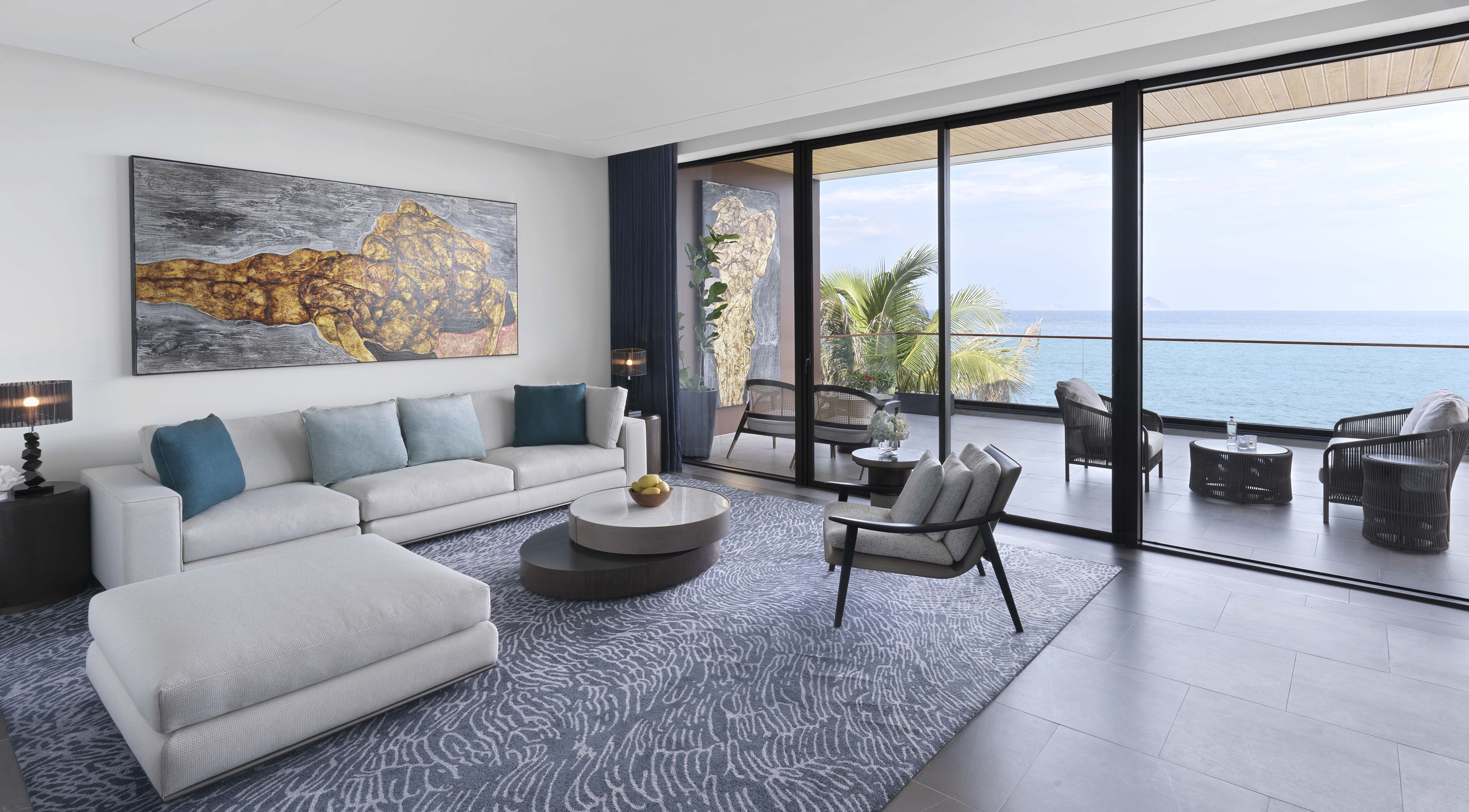 Luxury ocean view living room with modern decor, white sofa, and abstract art.