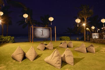 a group of pillows on grass with a screen in the background
