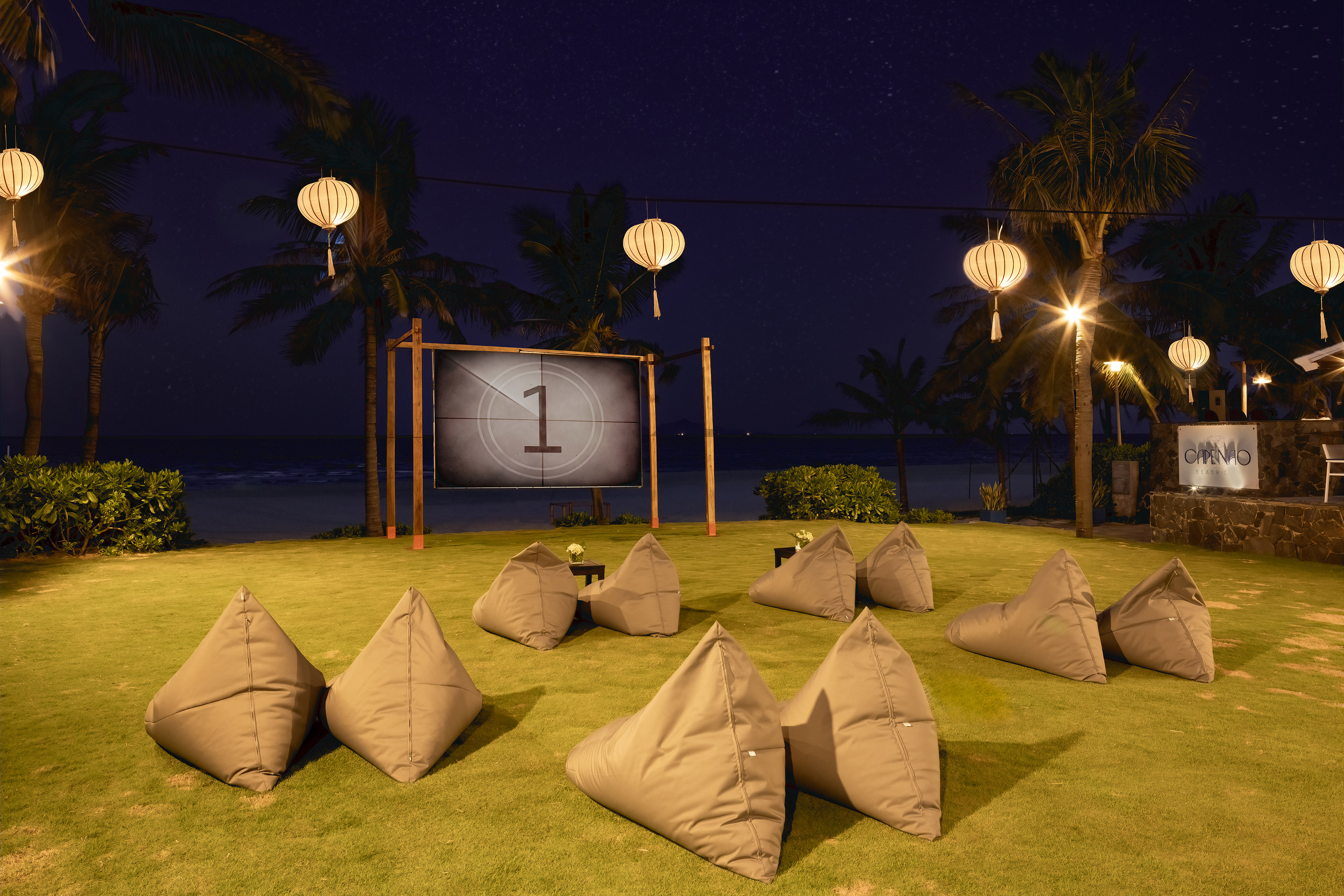 a group of pillows on grass with a screen in the background