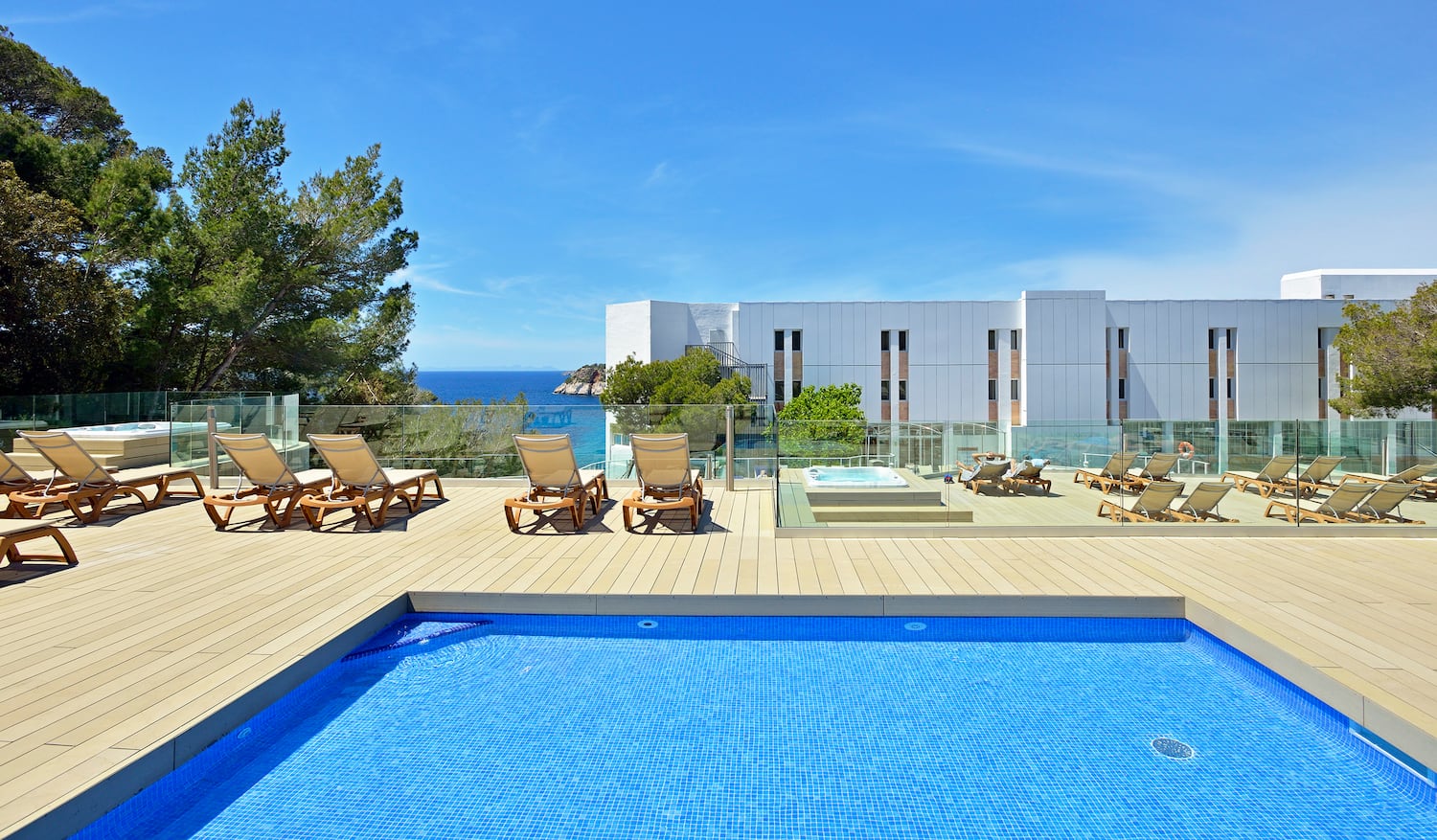 a pool with chairs and a building in the background