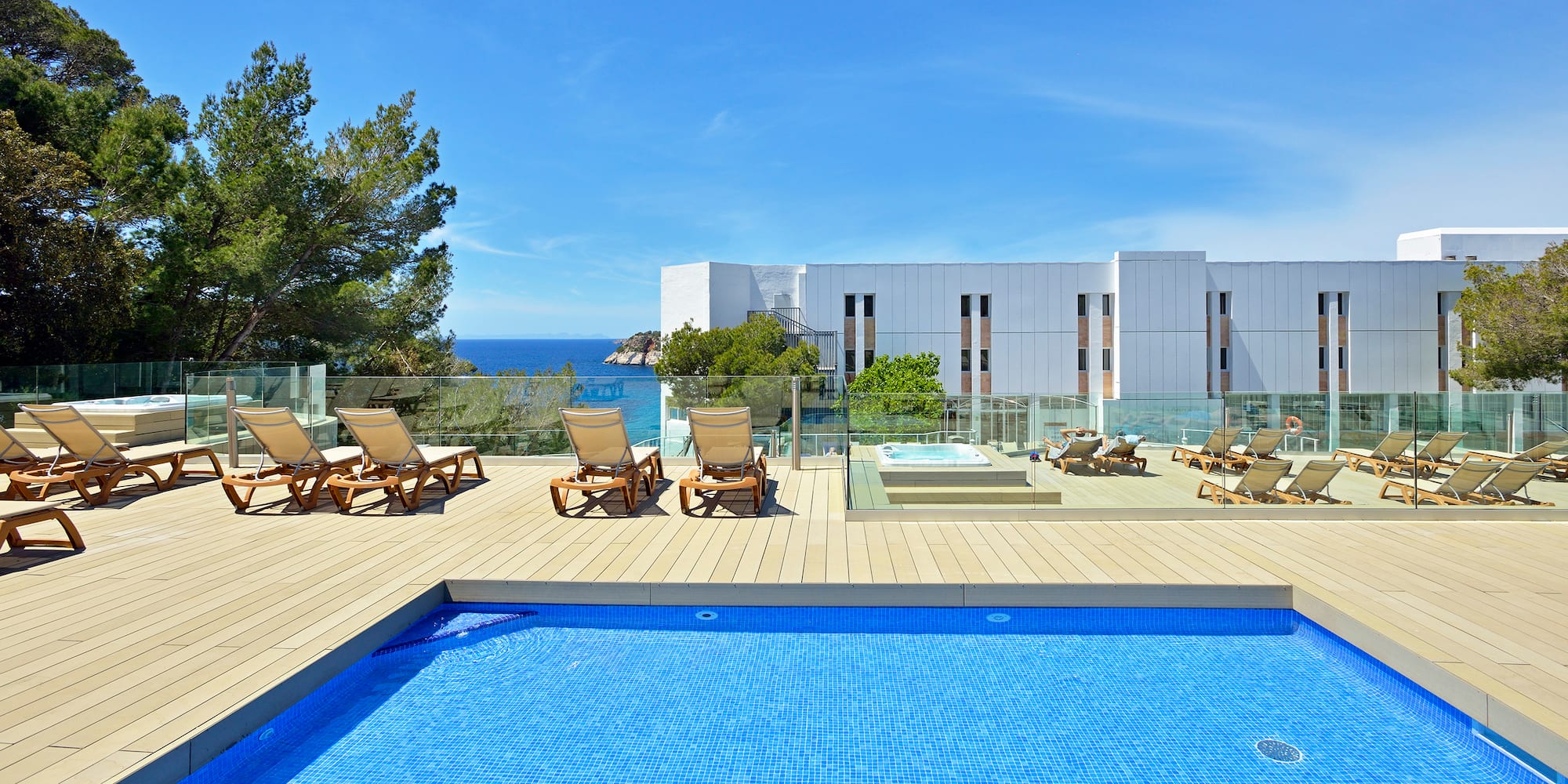 a pool with chairs and a building in the background