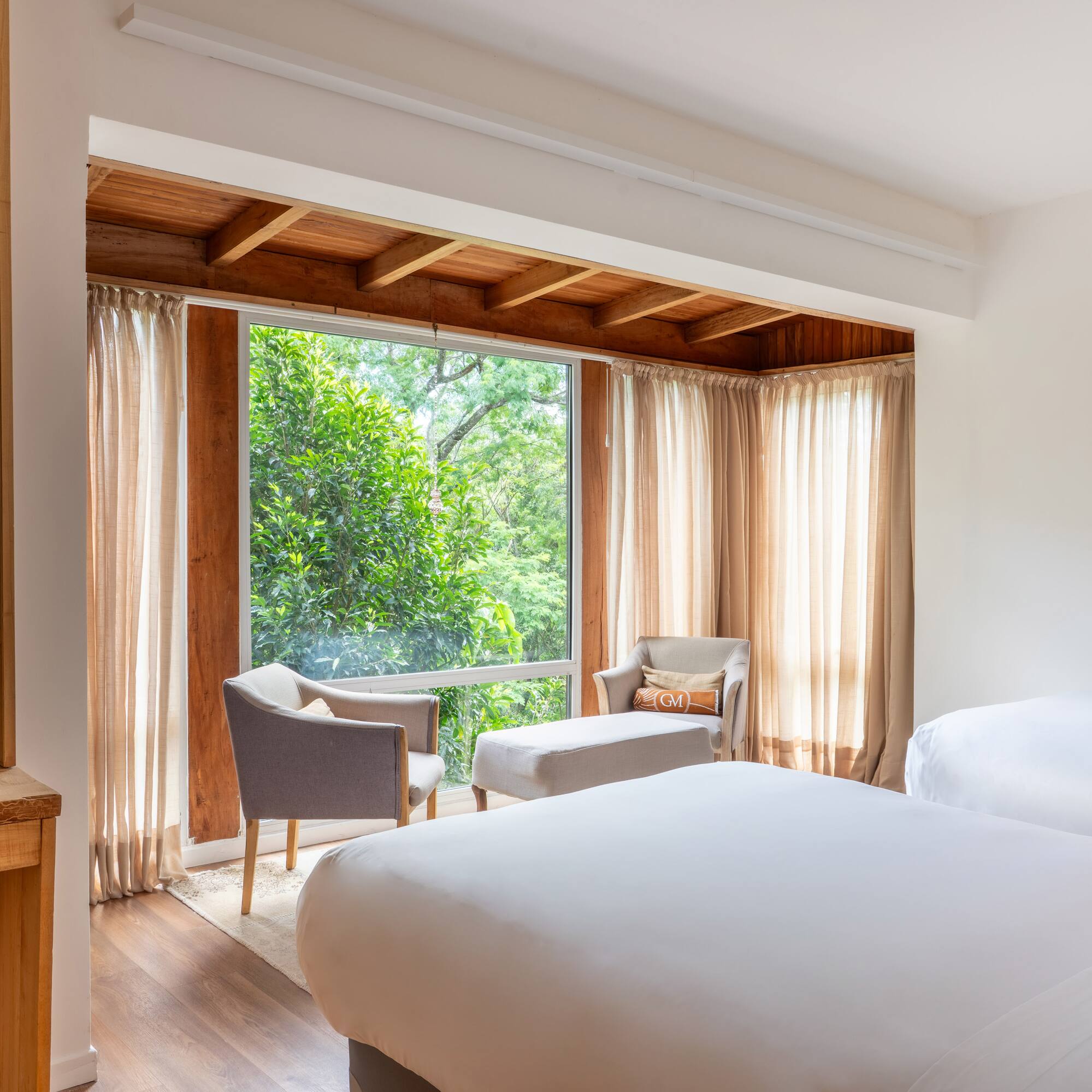 a room with a bed and chairs