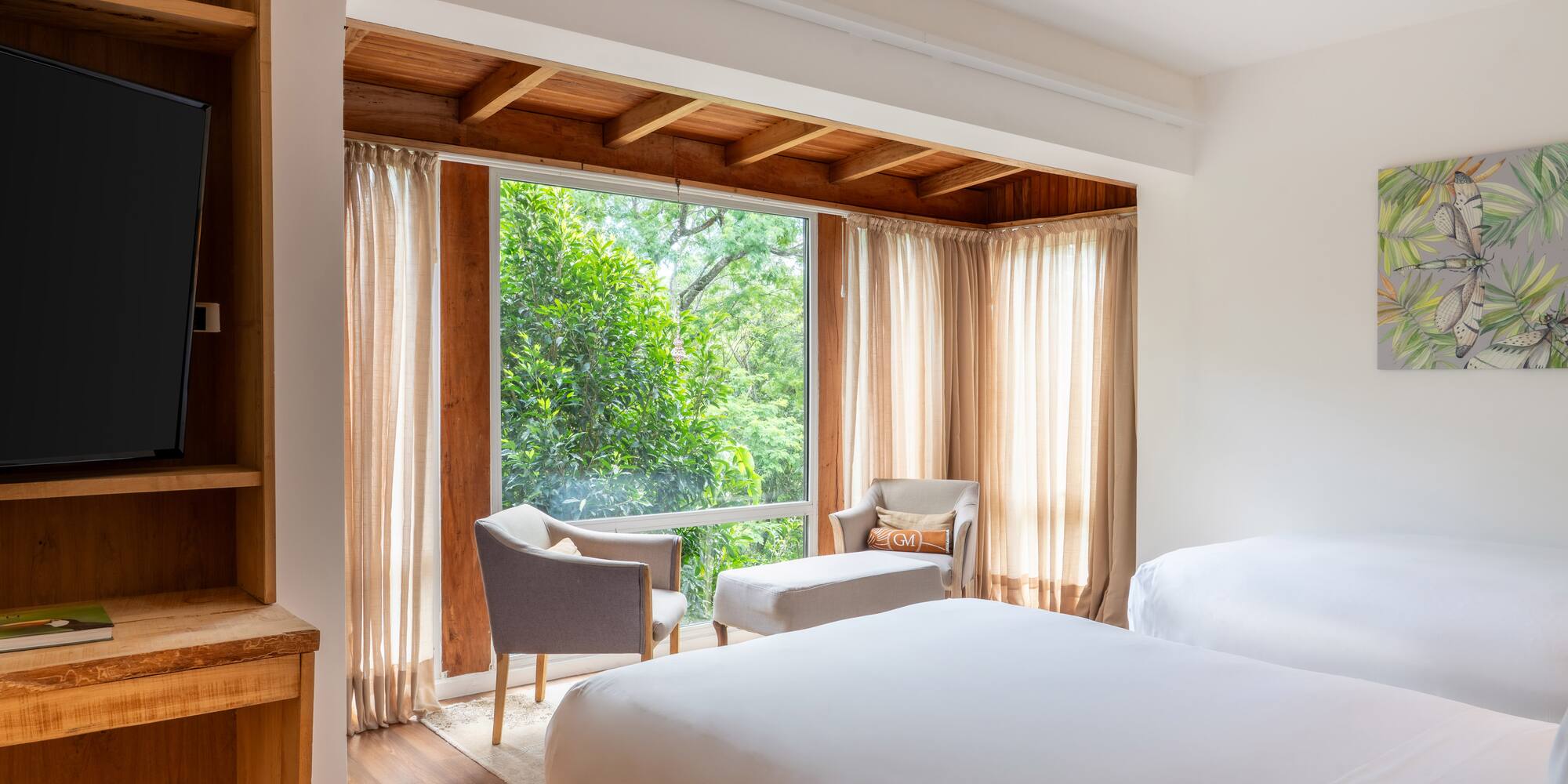 a room with a bed and chairs