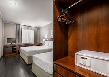 a room with two beds and a small white box