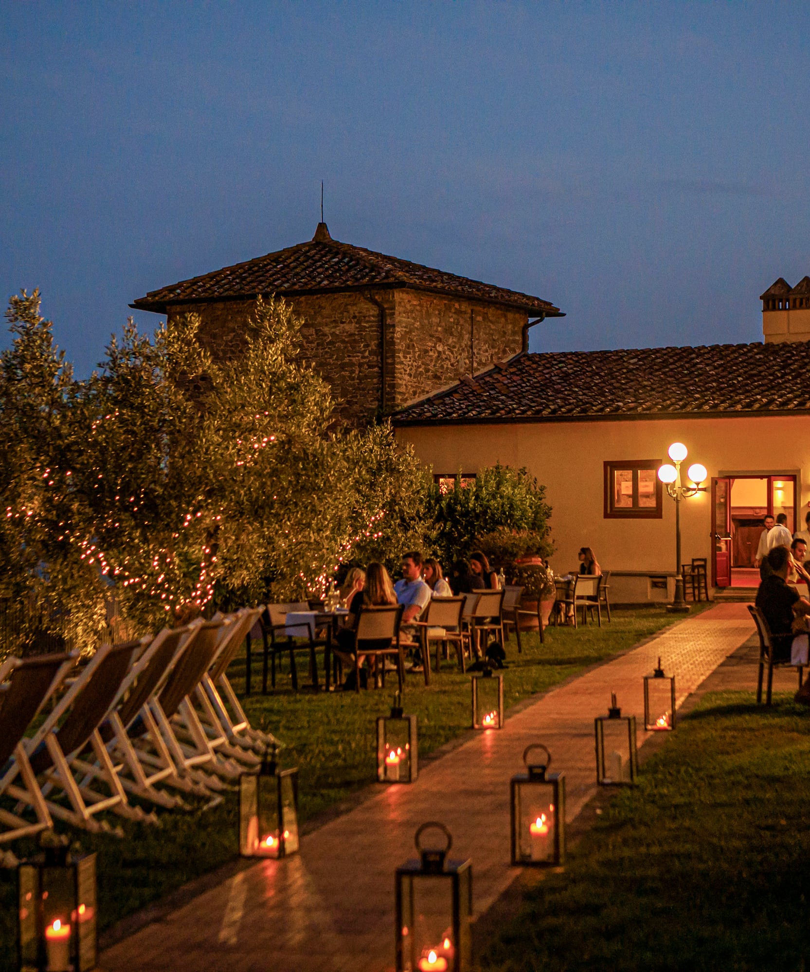 a group of people sitting at tables outside a building
