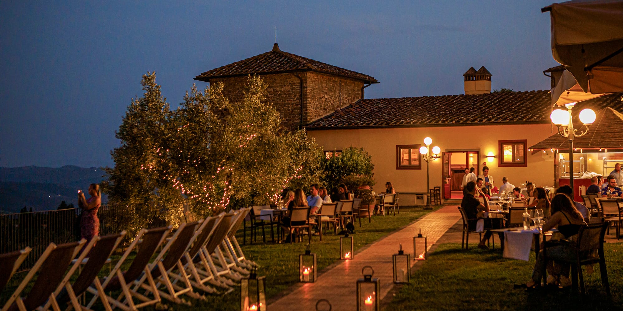 a group of people sitting at tables outside a building